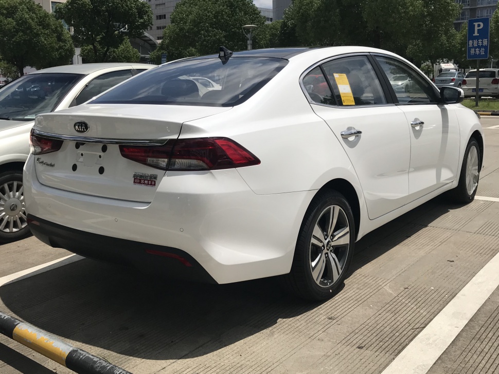 Rear and side profile of a white sedan with modern tail lights and alloy wheels.