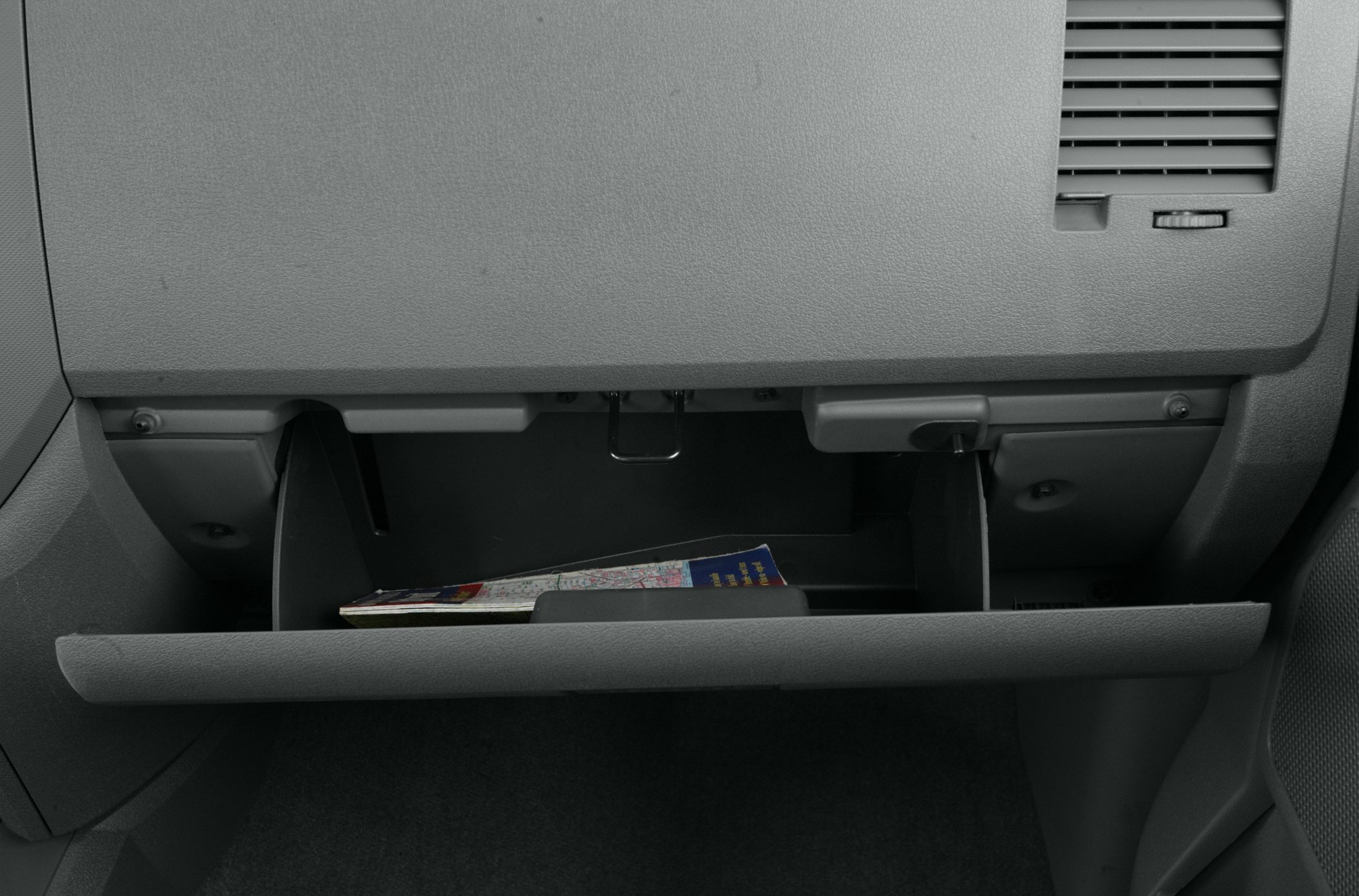 Open glove compartment with visible storage space and dashboard textures