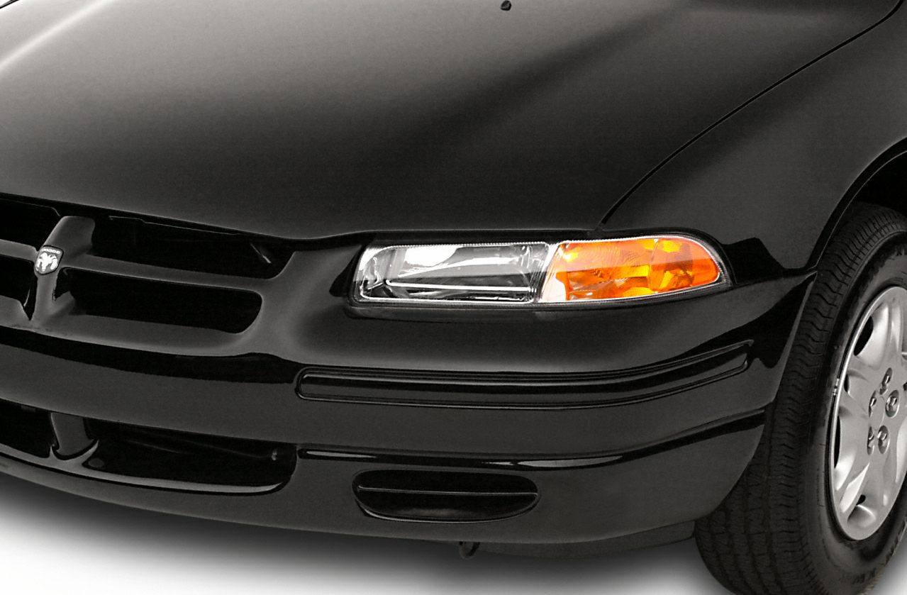 Front headlight, grille, and wheel close-up of a black vehicle