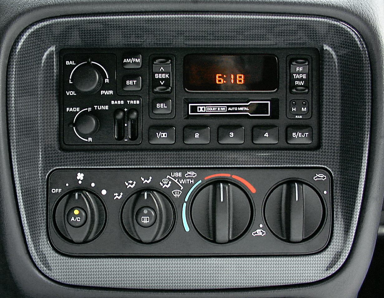 Classic car radio with cassette player and manual climate control knobs