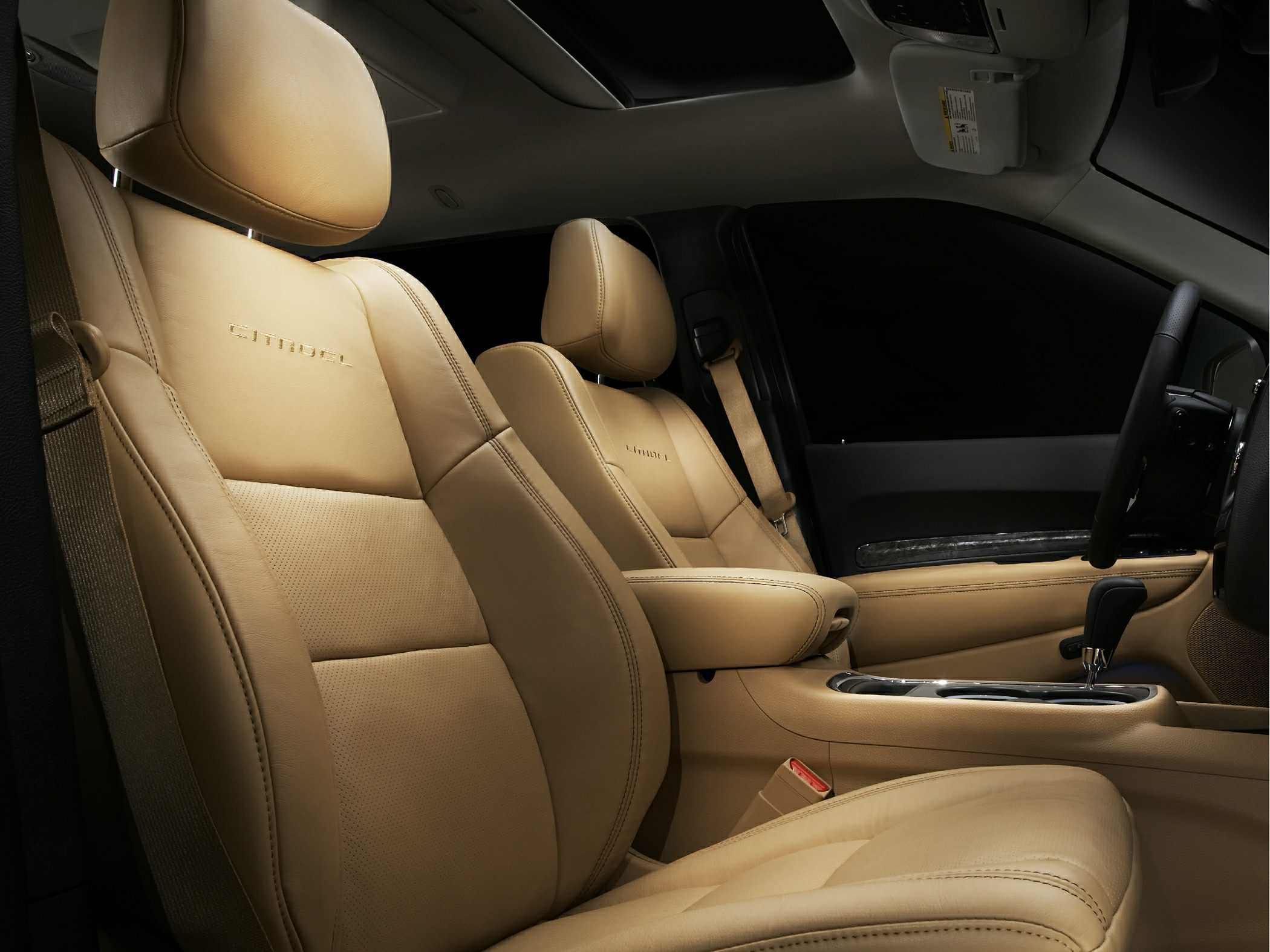 Beige leather front seats and center console with detailed stitching.