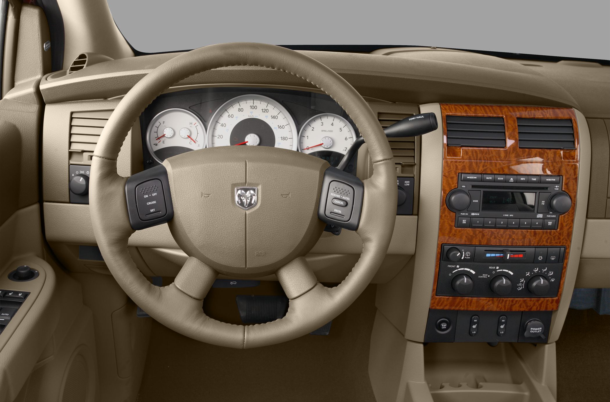 Beige steering wheel and wooden panel dashboard with controls