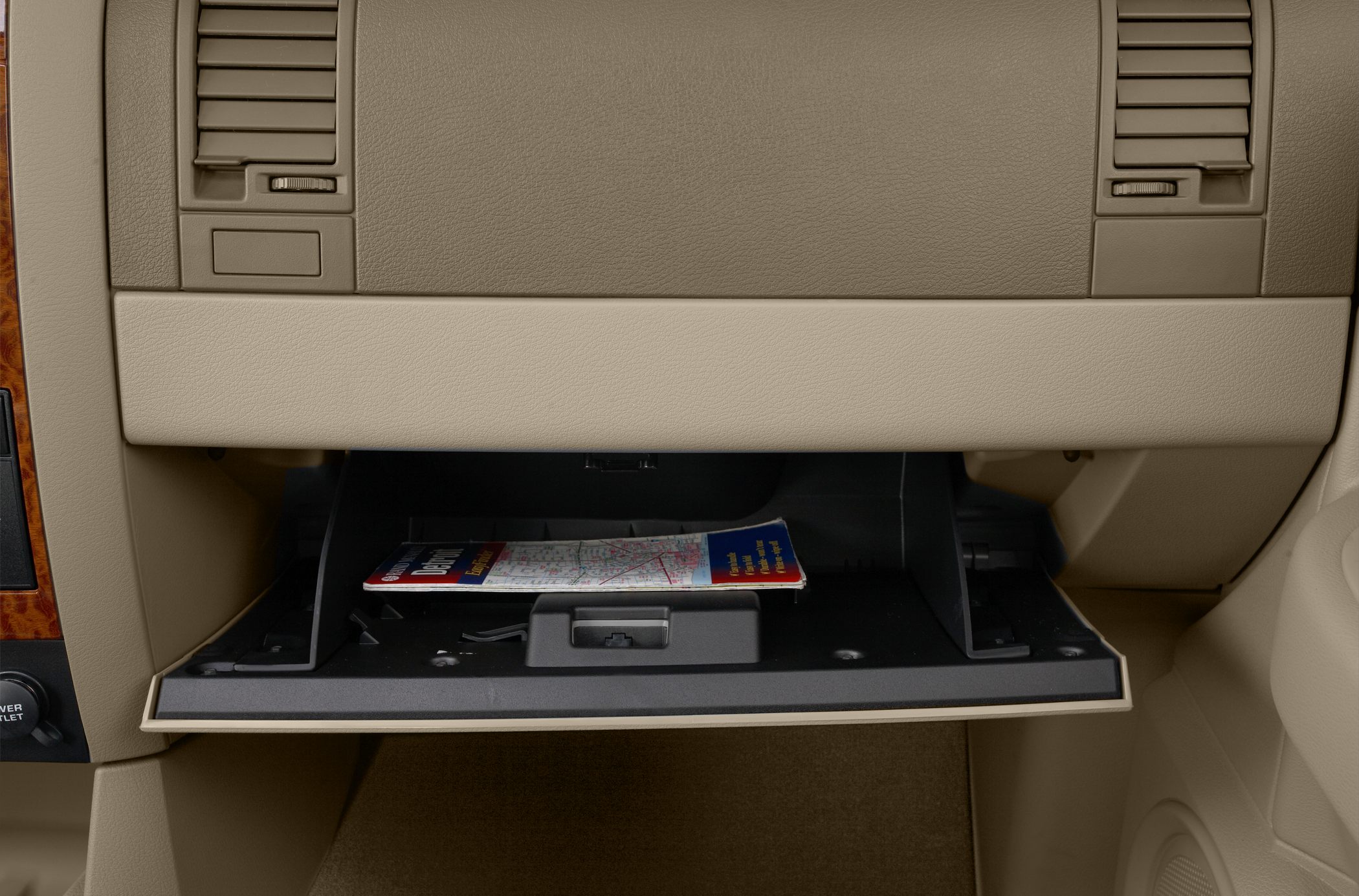 Open glove compartment with visible wood trim and beige interior.