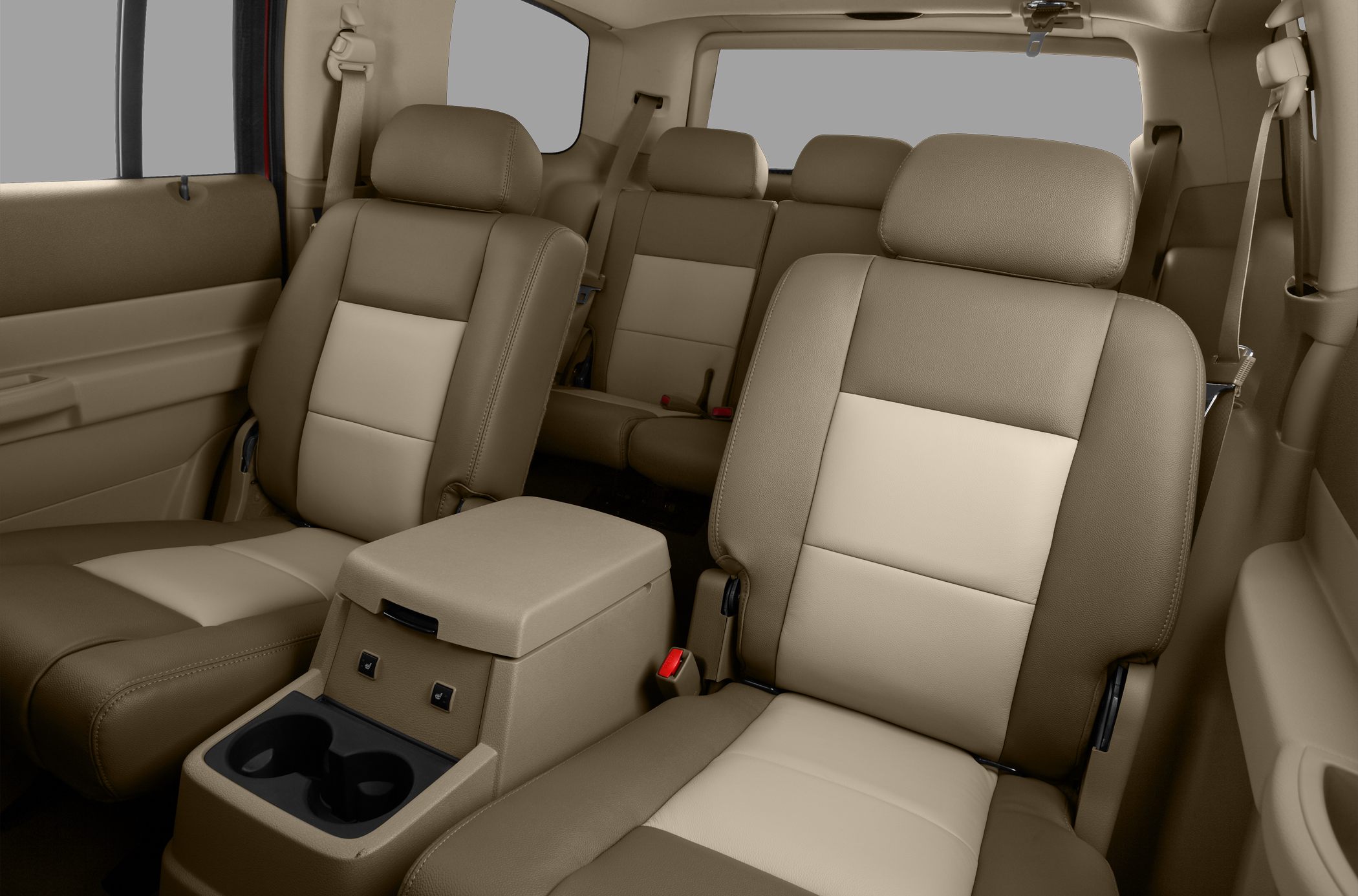 Beige two-tone leather seats with central armrest and cup holders in spacious three-row SUV interior
