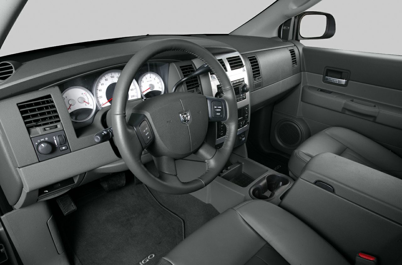 Steering wheel, instrument cluster, dashboard controls, and front cabin seating.