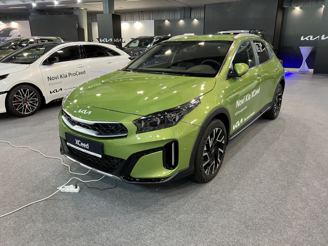 Green Kia XCeed displaying sharp headlights and sporty front grille.