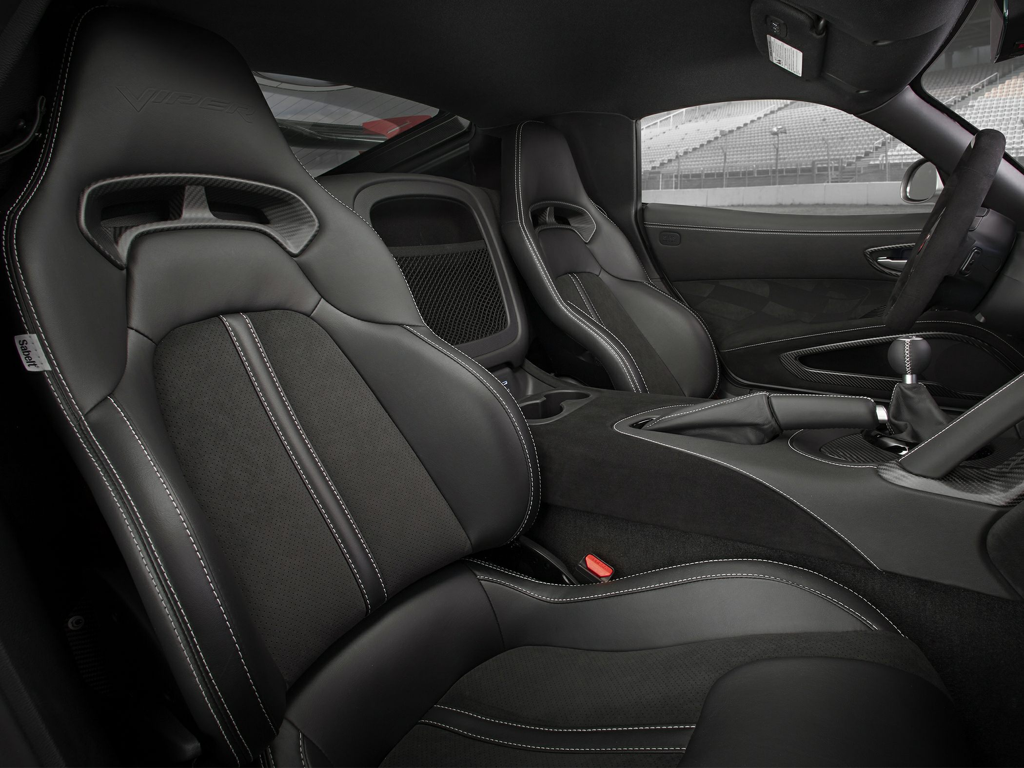 Black sport seats with detailed stitching and manual gearshift in cockpit.