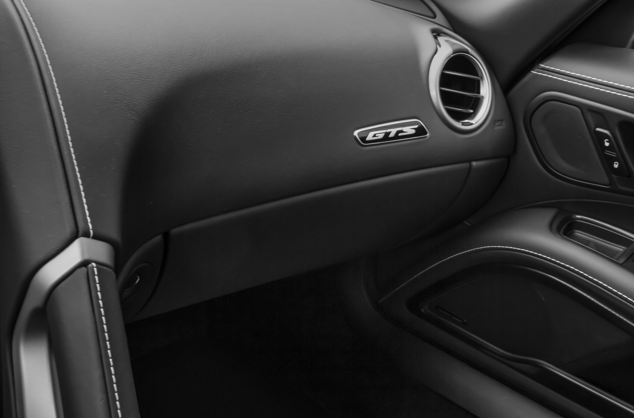Black leather dashboard with GTS badge and detailed white stitching.