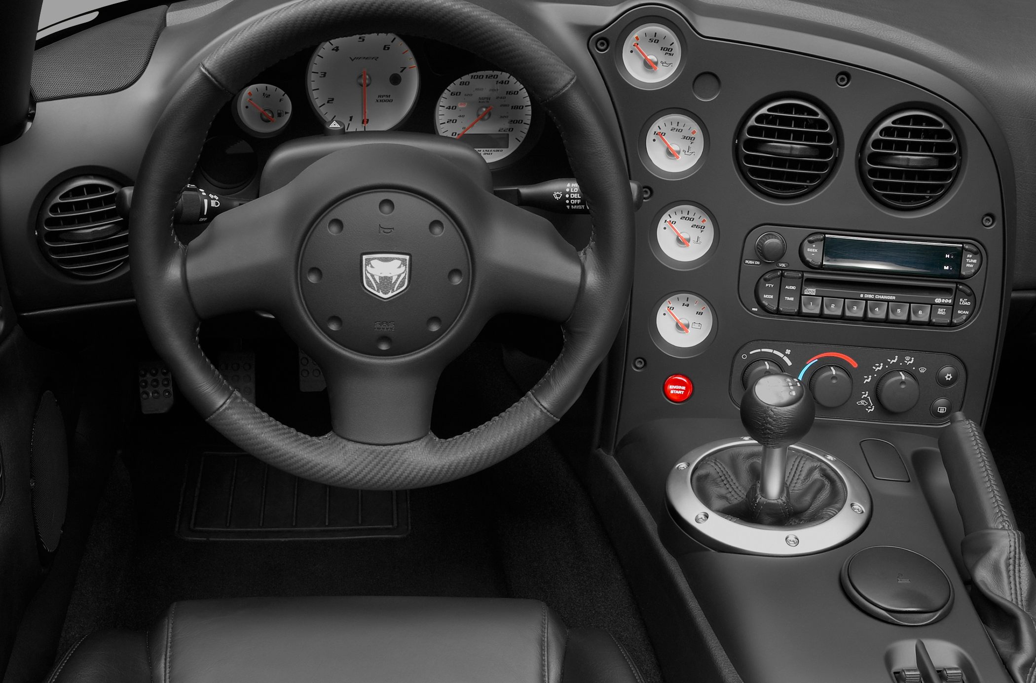 Dashboard, steering wheel, manual gear shift, and gauges in sports car interior