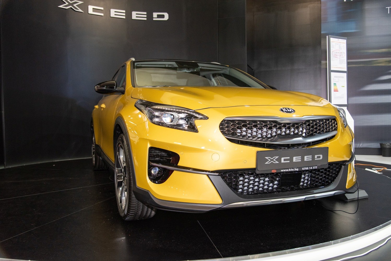 Front close-up showing headlights and grille of a yellow crossover