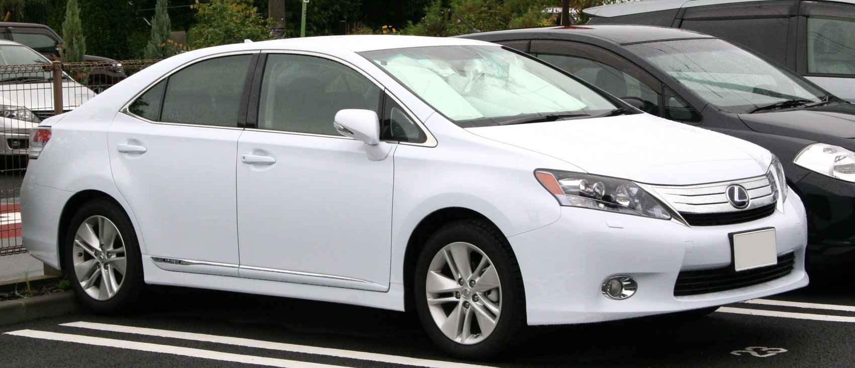 Sleek sedan side profile and distinctive front grille with headlight cluster