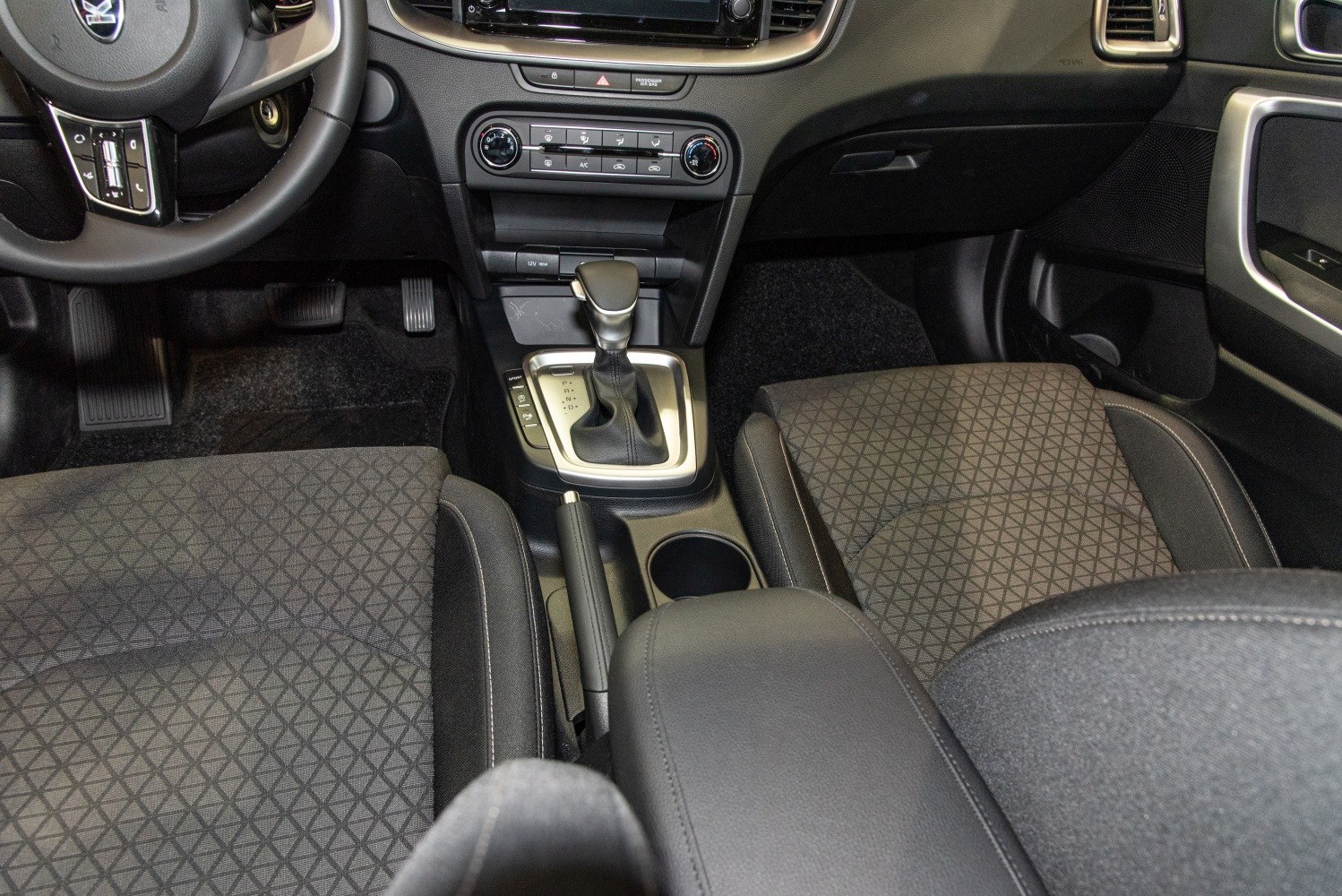 Car interior featuring gear shift, center console, and fabric seats