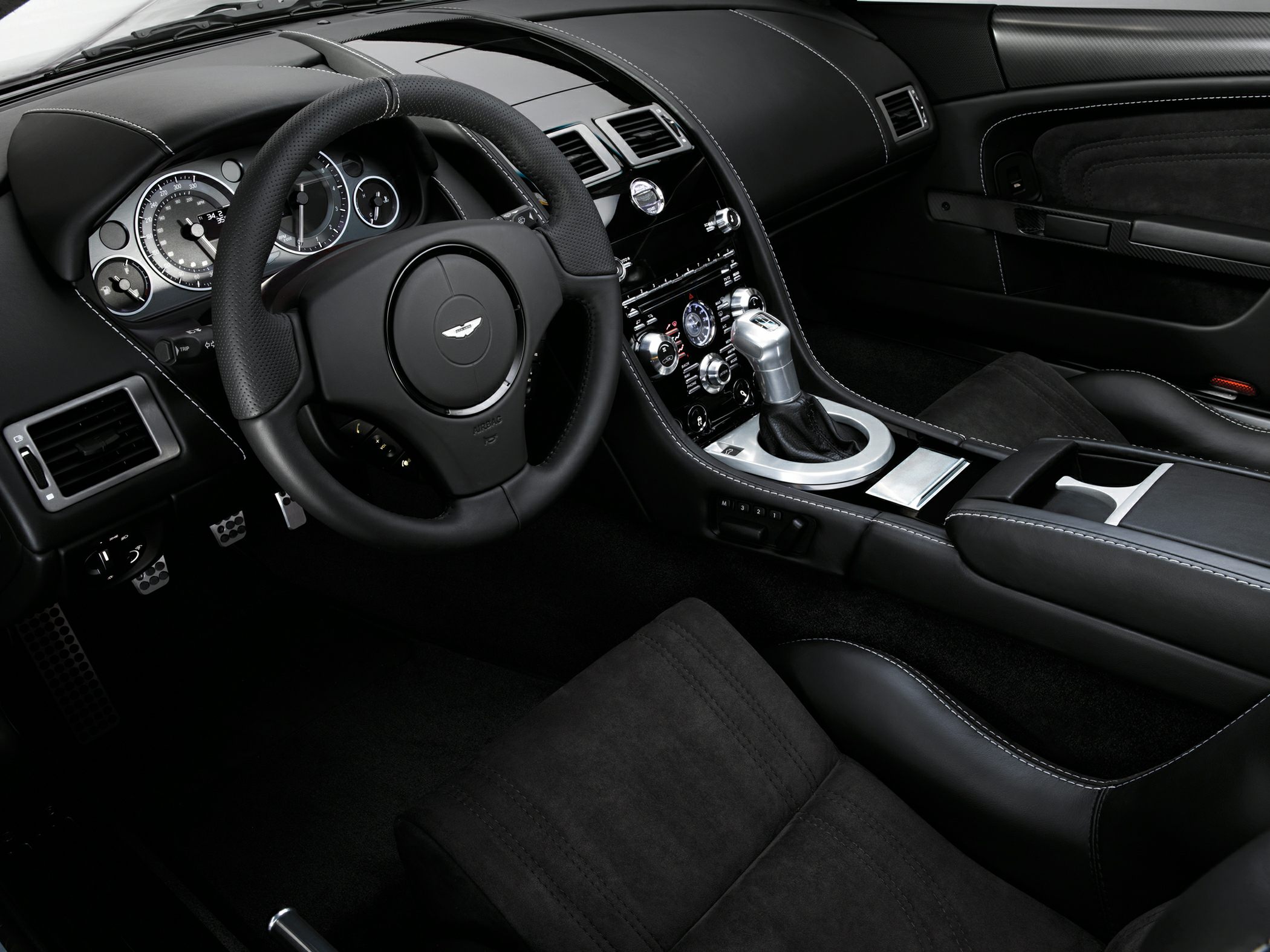 Luxury perforated leather steering wheel and manual gear shifter.