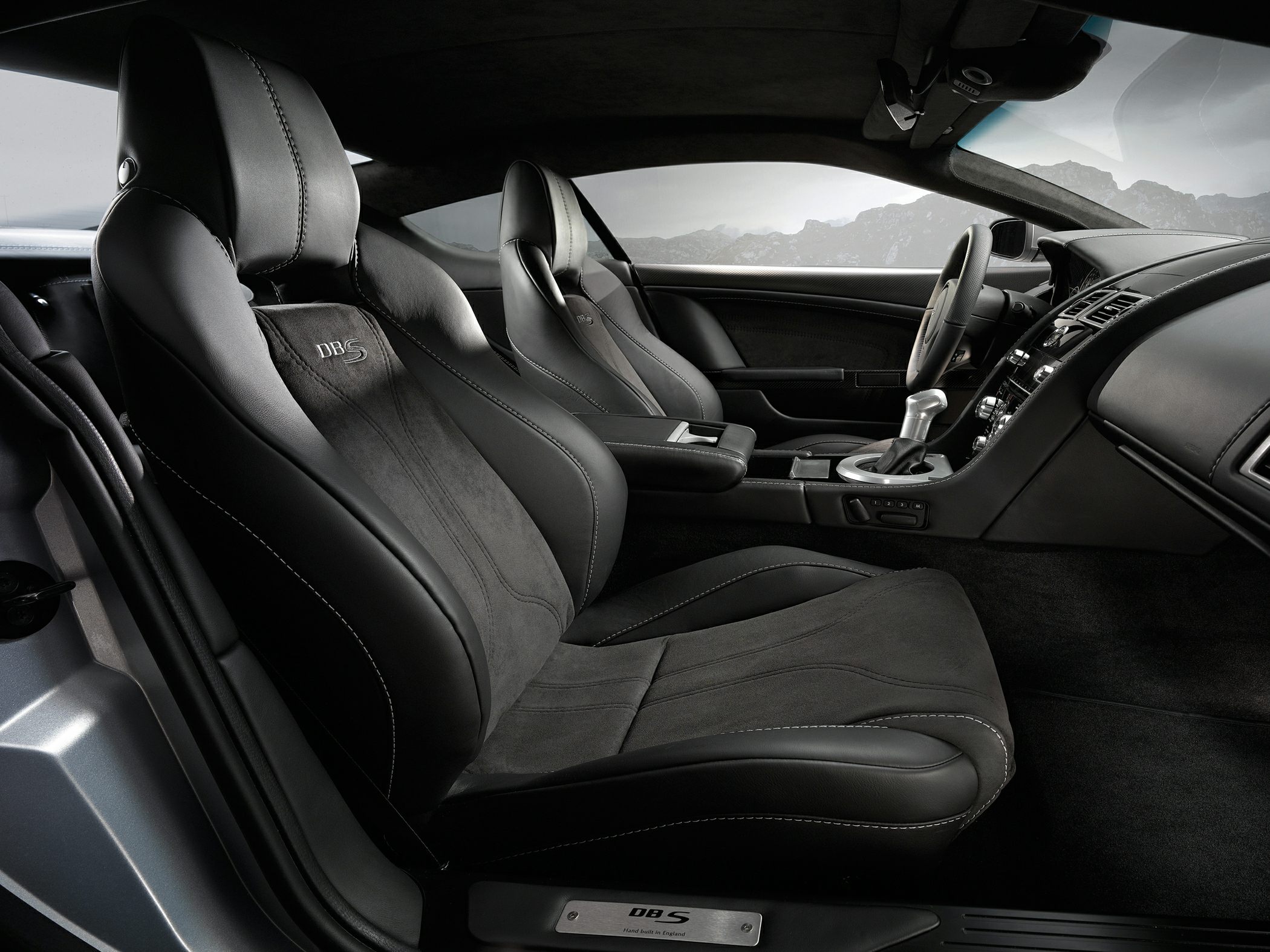 Black leather and Alcantara sports seats with visible stitching in luxury coupe interior