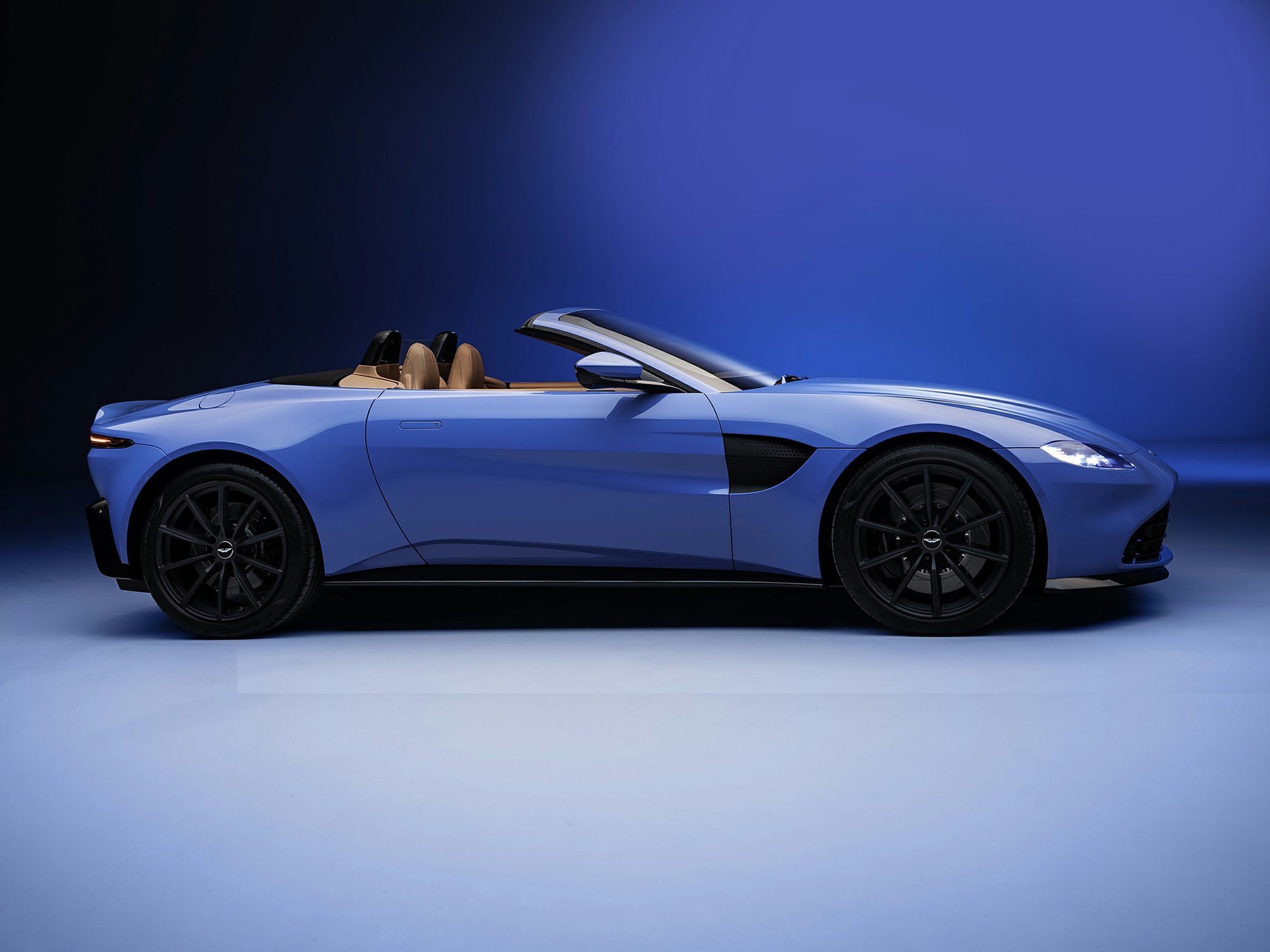 Blue convertible roadster with open roof and aerodynamic design side profile