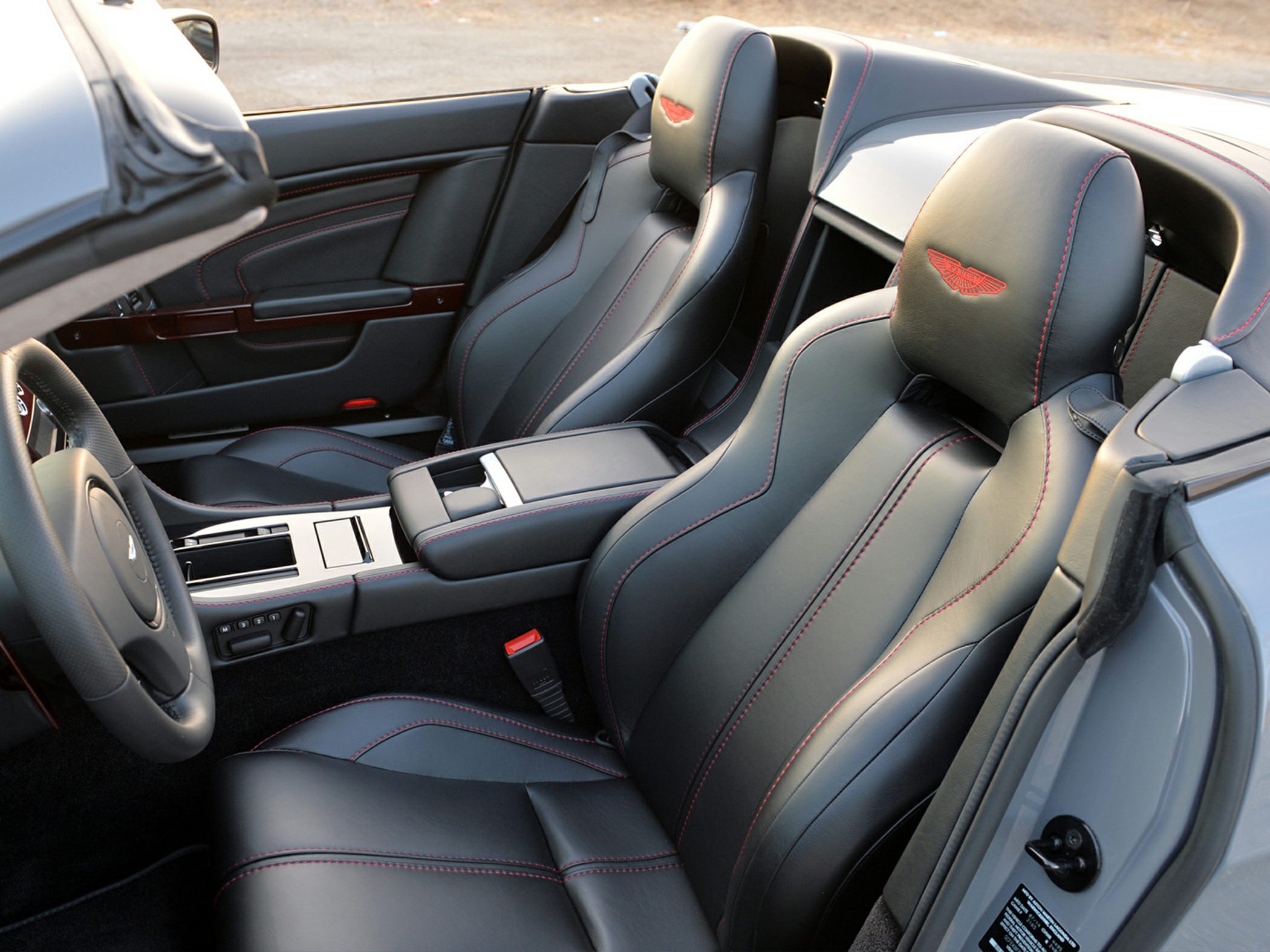 Black leather sport seats with red stitching and Aston Martin embossed headrests