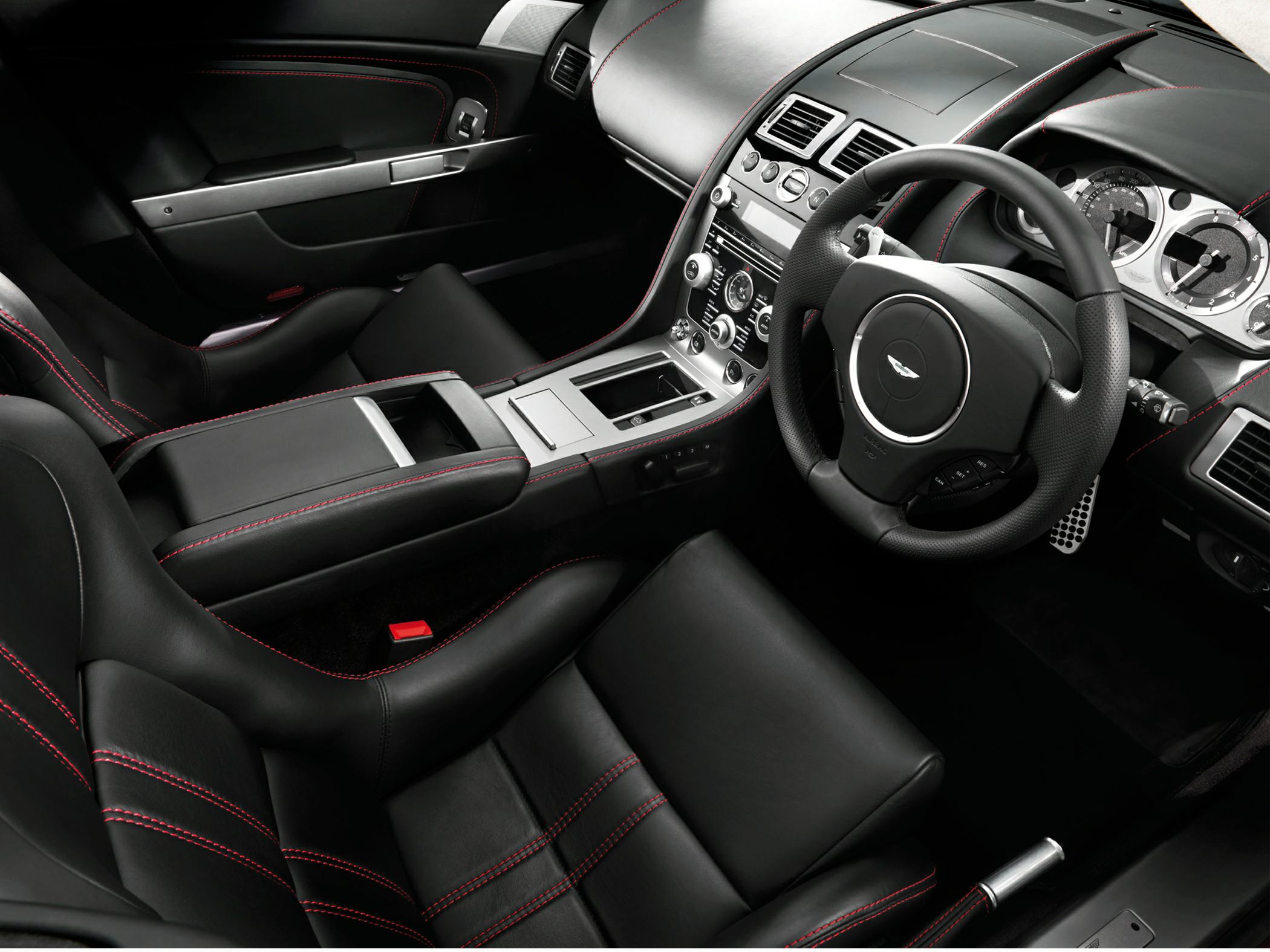 Black leather interior with red stitching and detailed dashboard layout.