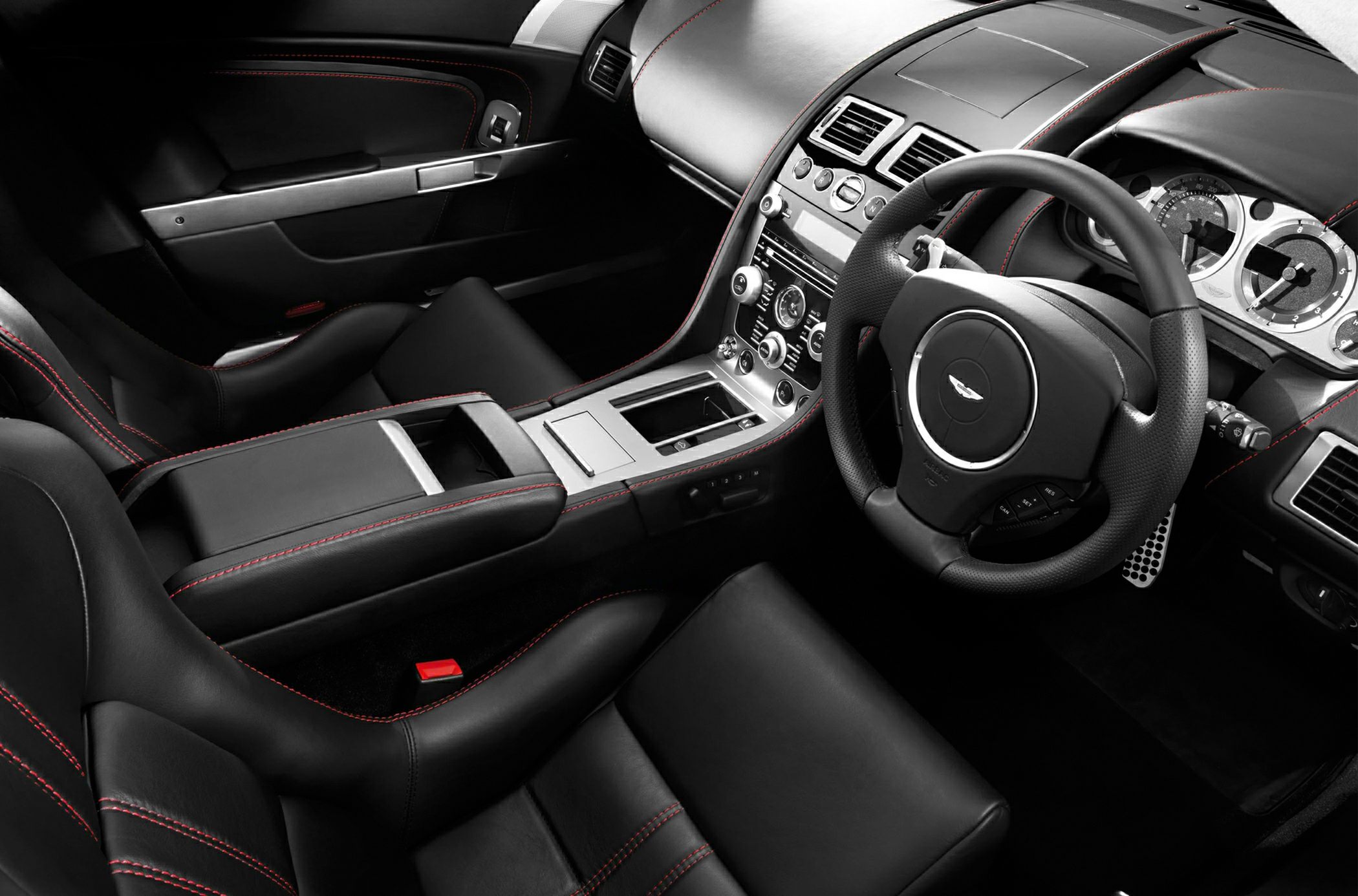 Black leather interior with red stitching and detailed dashboard
