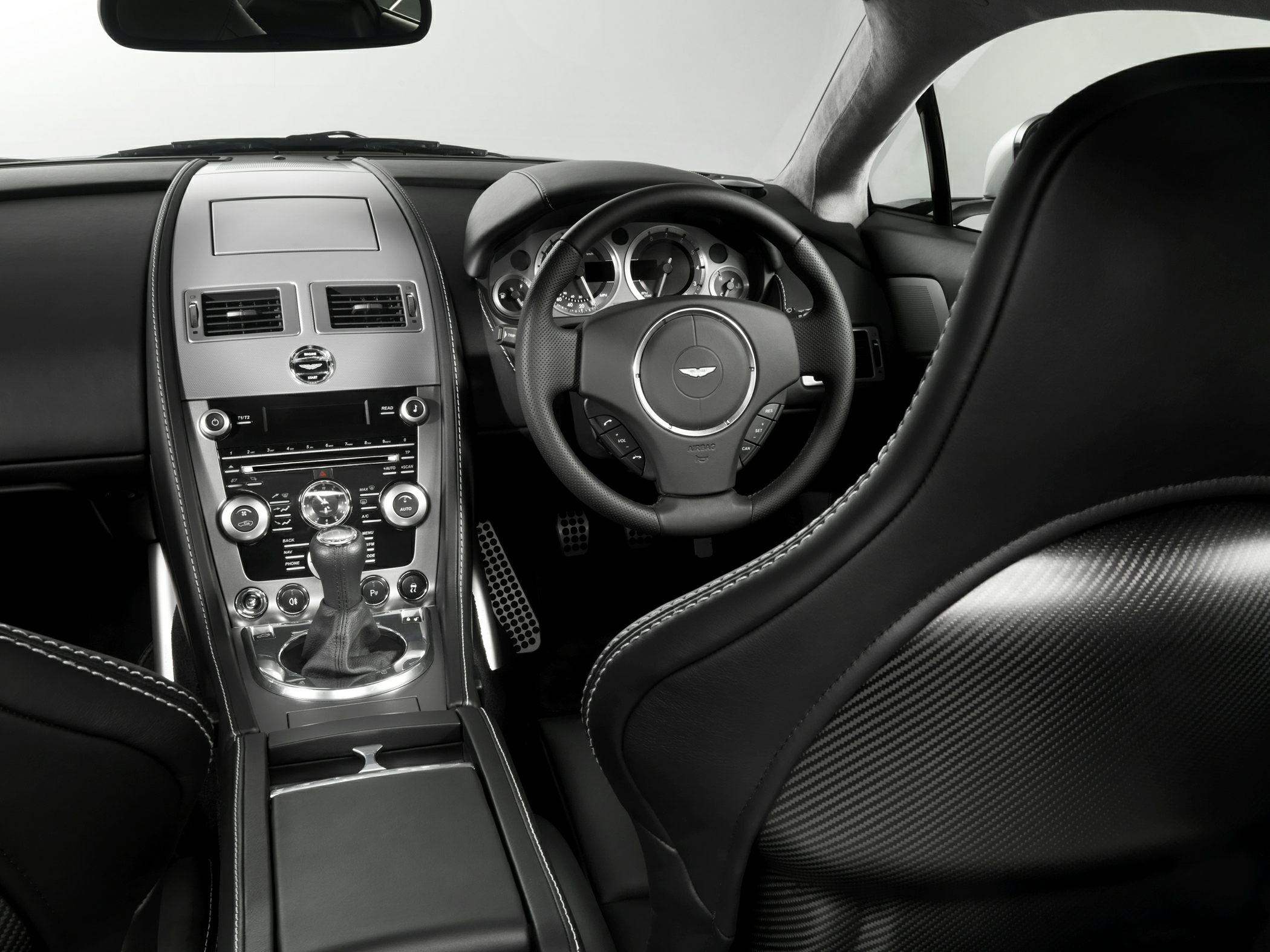 Right-hand drive luxury sports car interior with manual gearbox and carbon fiber