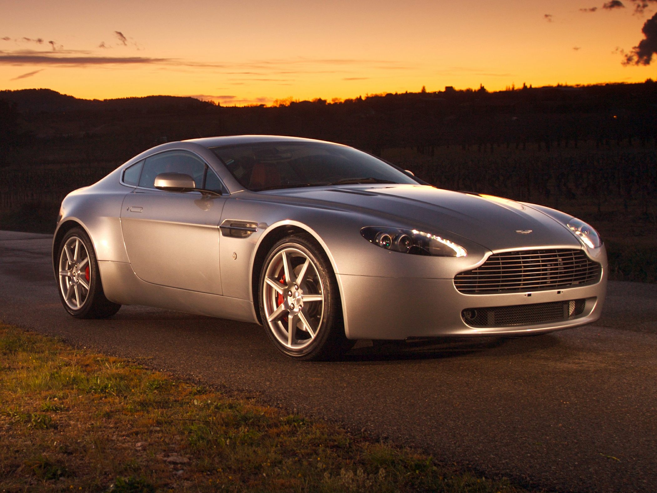 Sleek front and side profile of a silver sports coupe at sunset