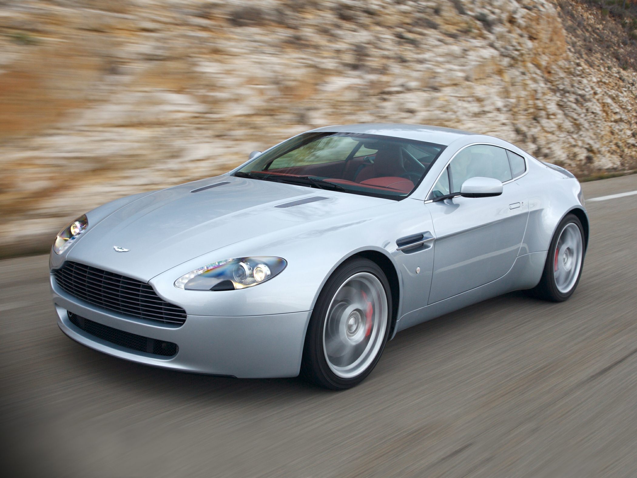 Sleek silver sports coupe with aerodynamic lines and spinning alloy wheels
