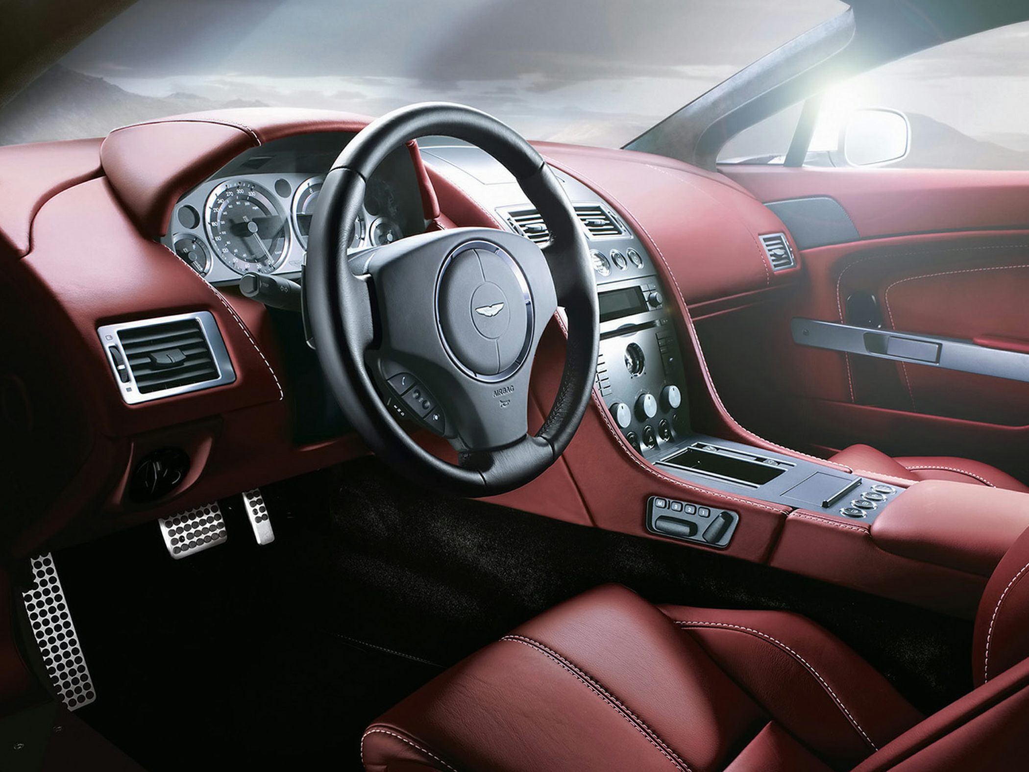 Red leather interior with sports steering wheel and detailed dashboard.