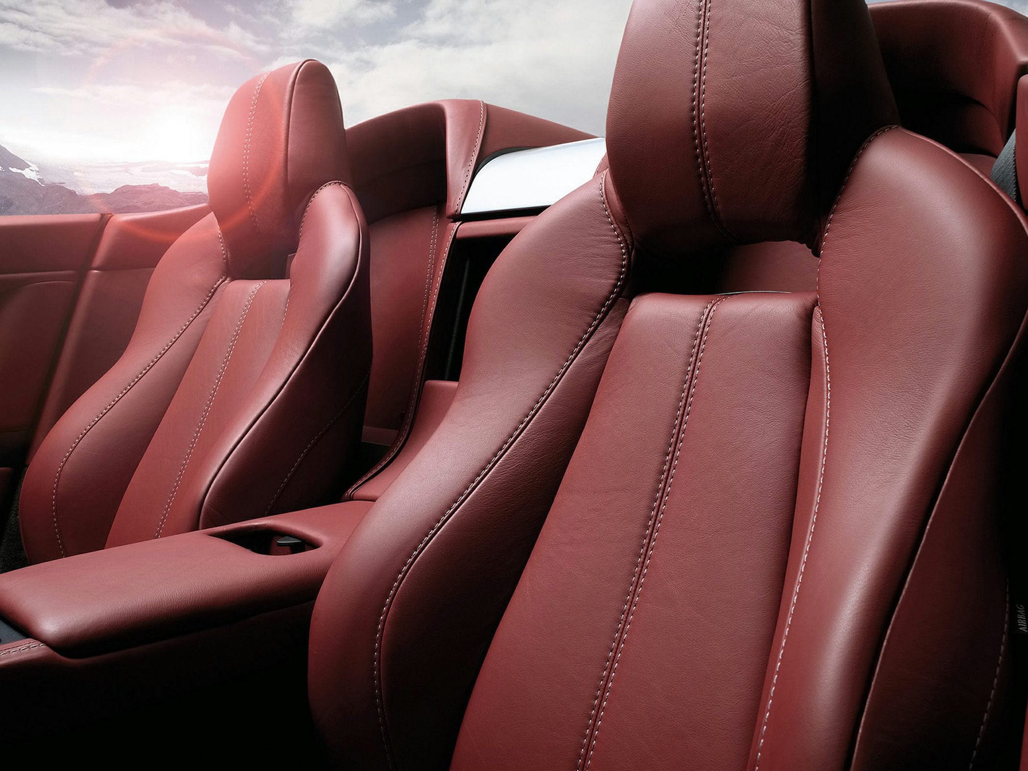 Close-up of red leather sports seats with detailed stitching.