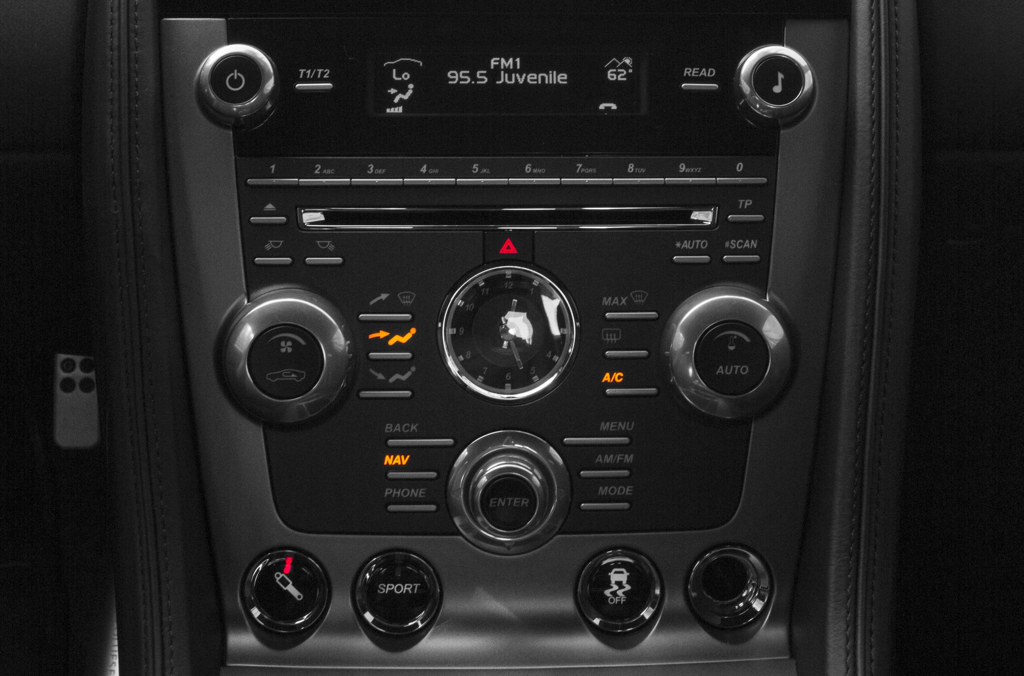 Analog clock, climate control knobs, and multimedia interface in luxury car center console