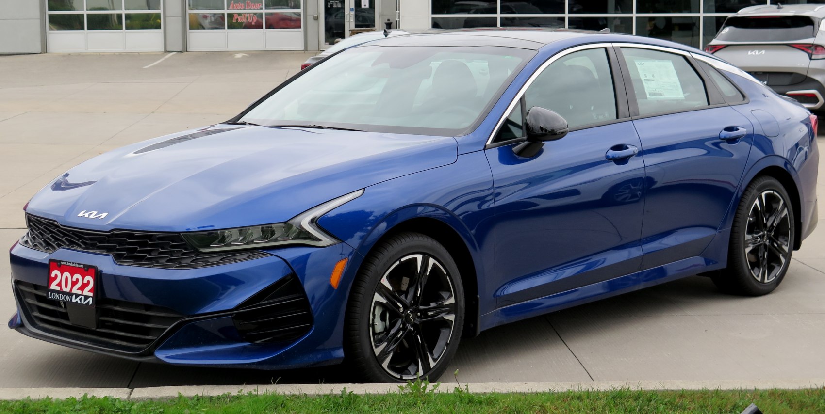 Sleek blue modern sedan with black alloy wheels and sharp front headlights
