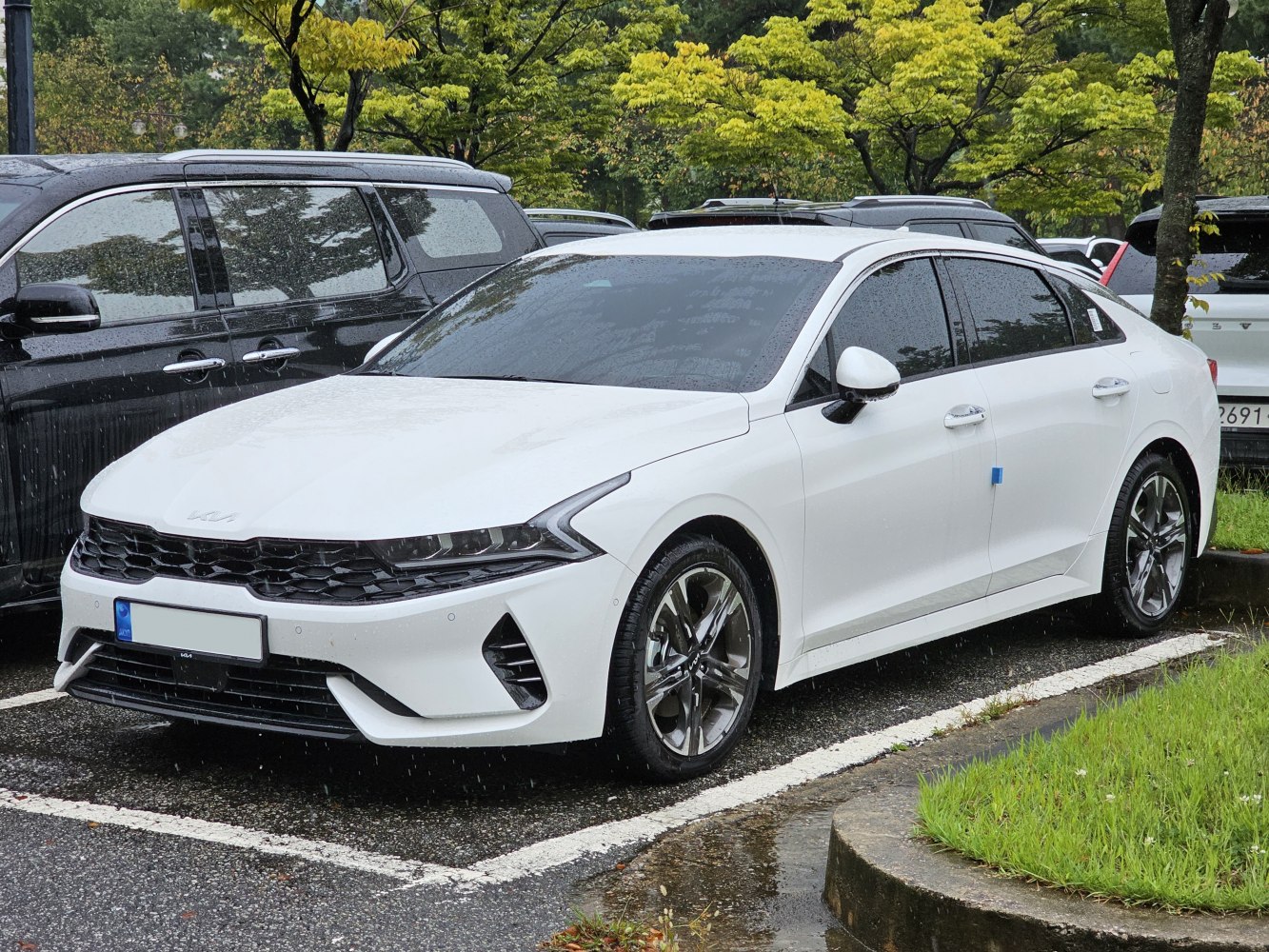 Sleek LED headlights and honeycomb front grille on white sedan