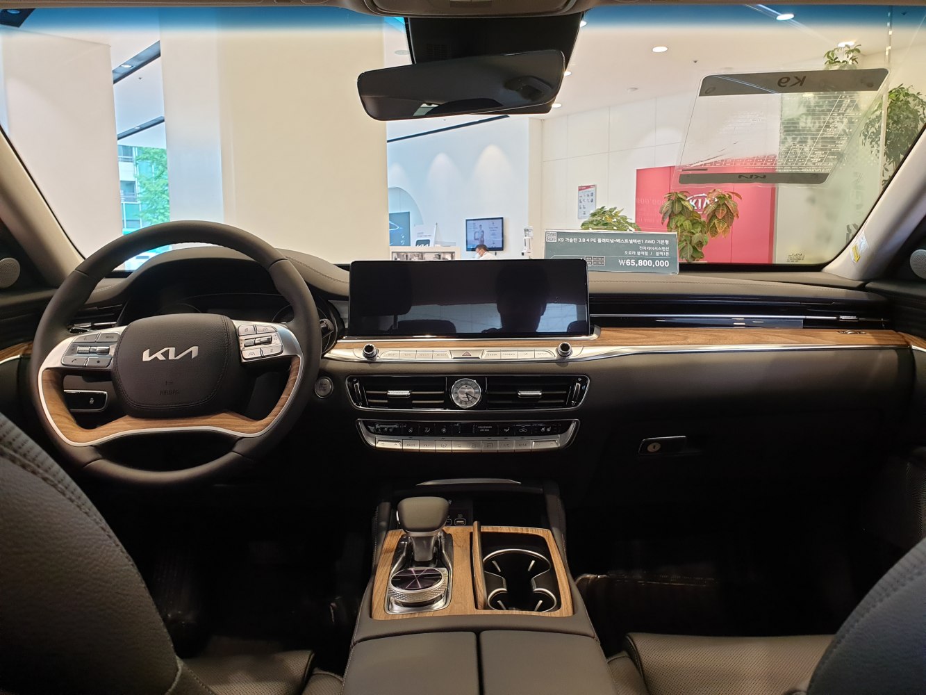 Wood-trimmed steering wheel and digital dashboard display.