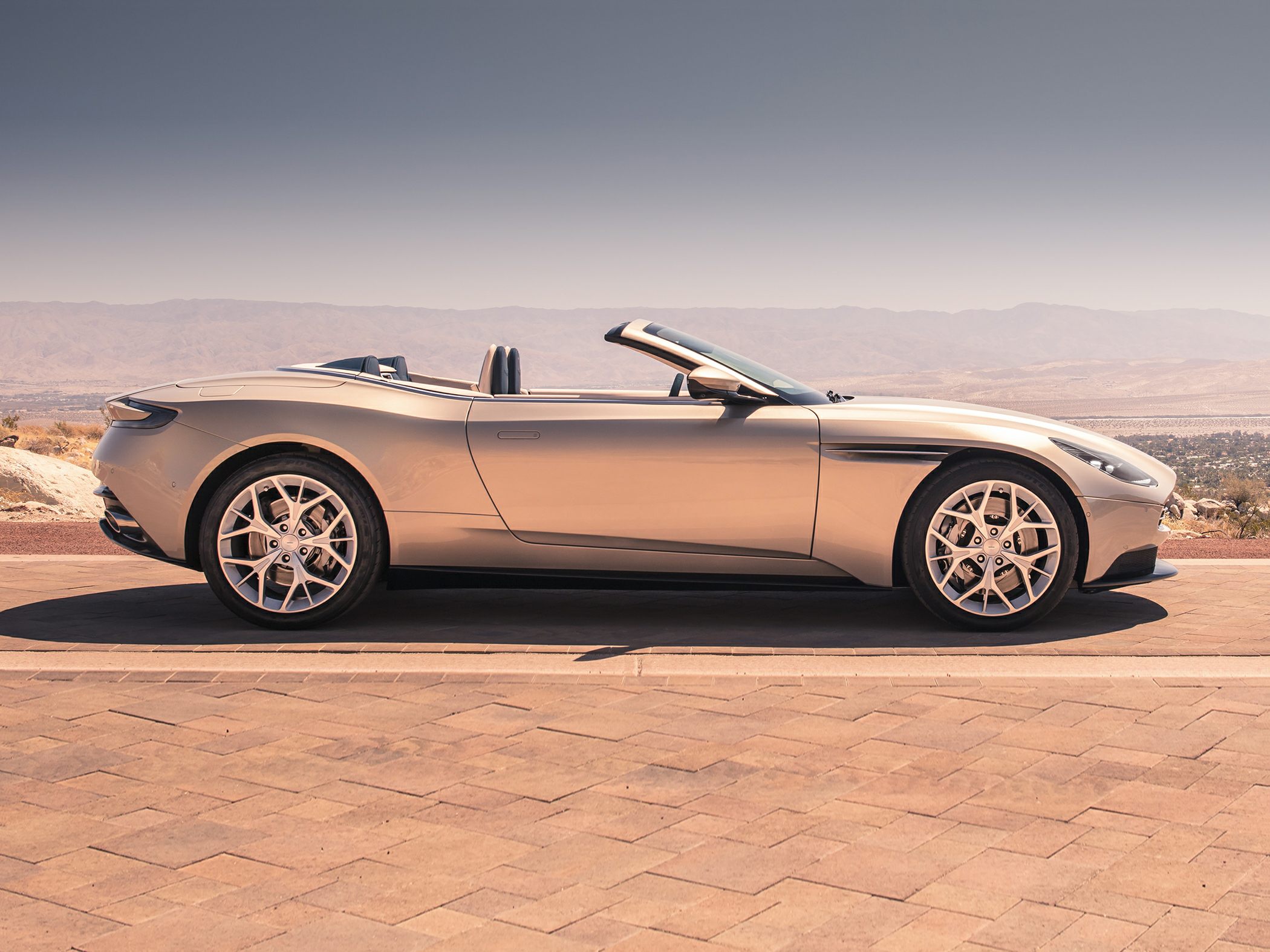 Sleek convertible side profile with distinctive open roof and alloy wheels