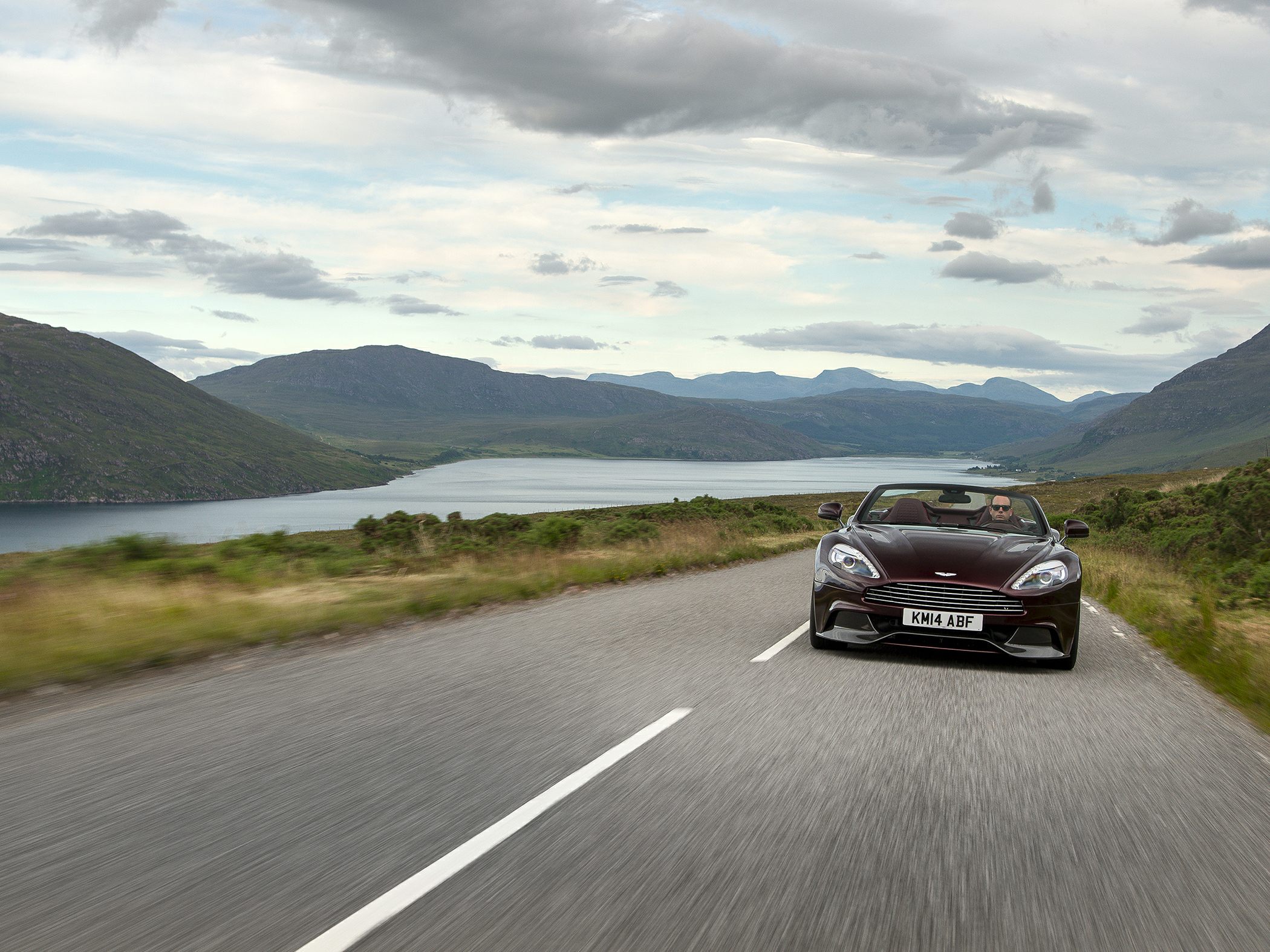 Front view convertible with sleek grille and headlights on a scenic road