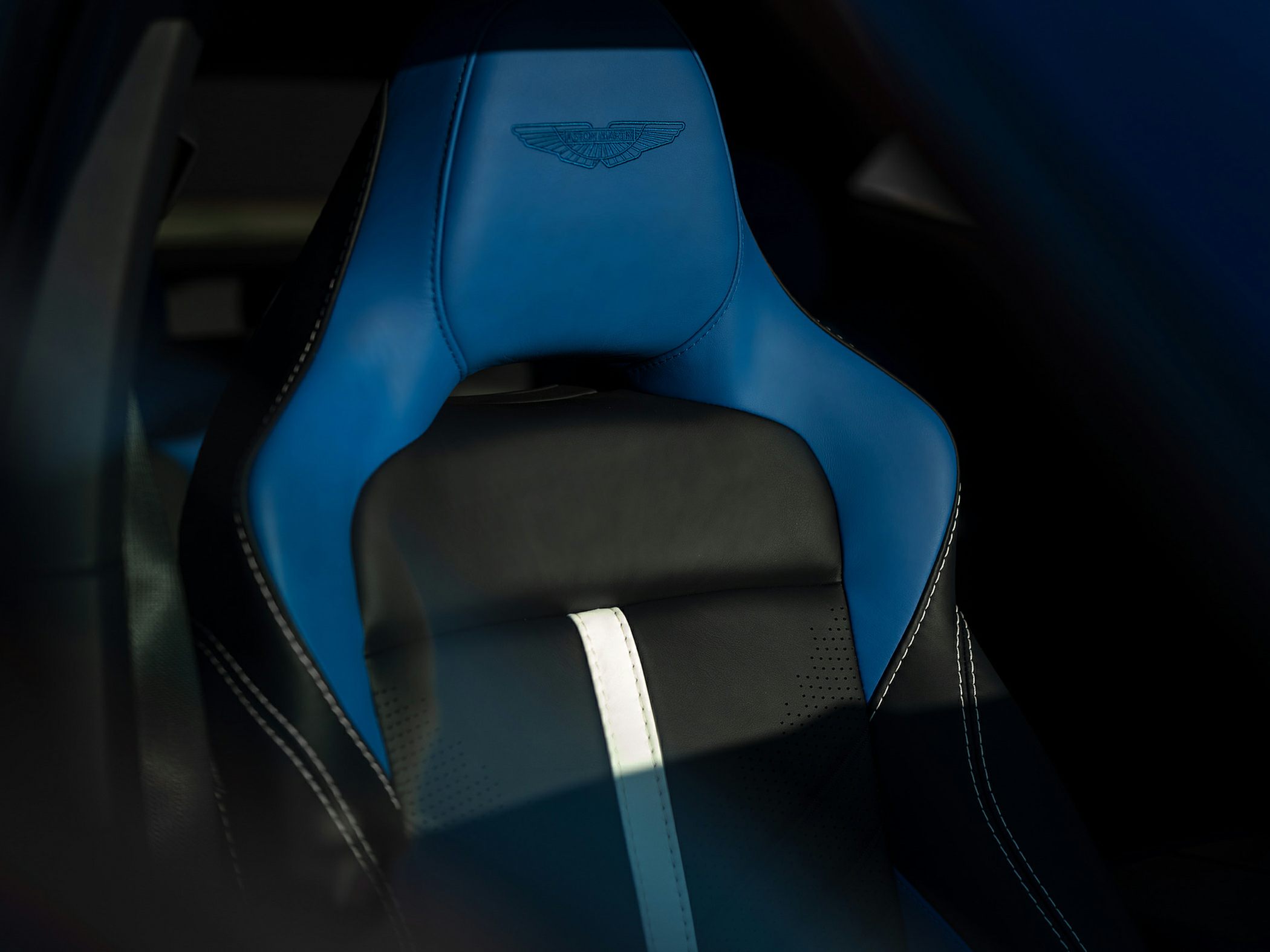 Blue and black leather sport seat with white stripe and embossed emblem