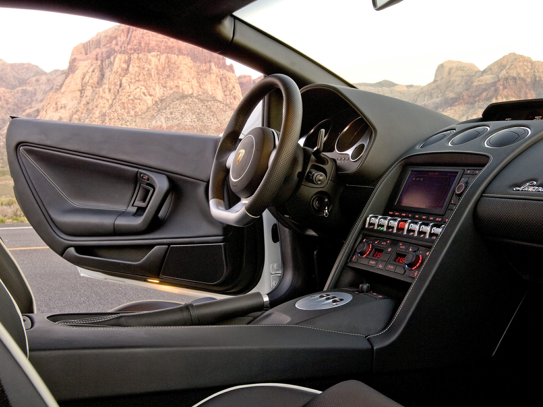 Steering wheel and dashboard with controls and display in luxury sports car interior