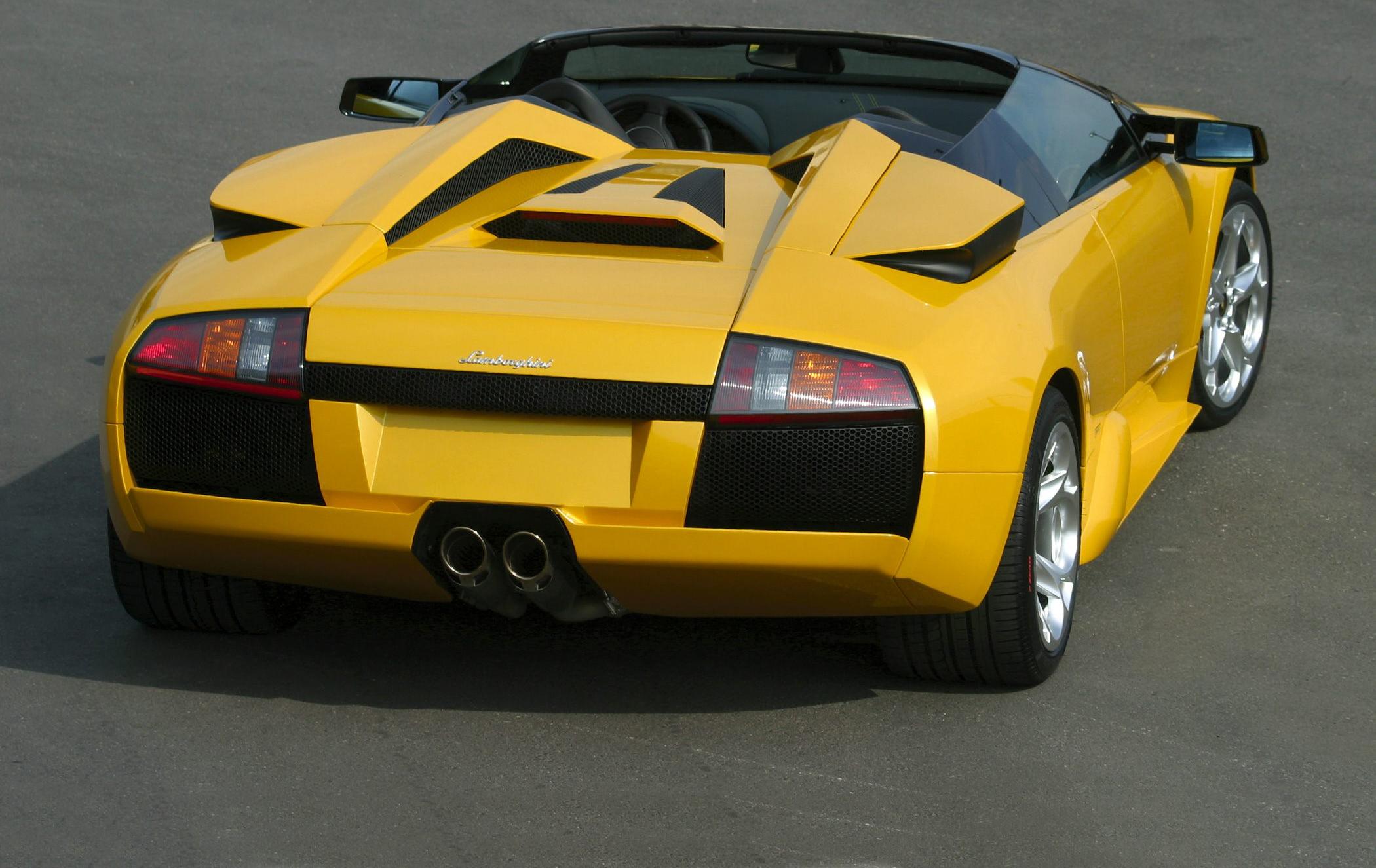 Yellow convertible with twin exhaust, distinctive rear design, aerodynamic vents