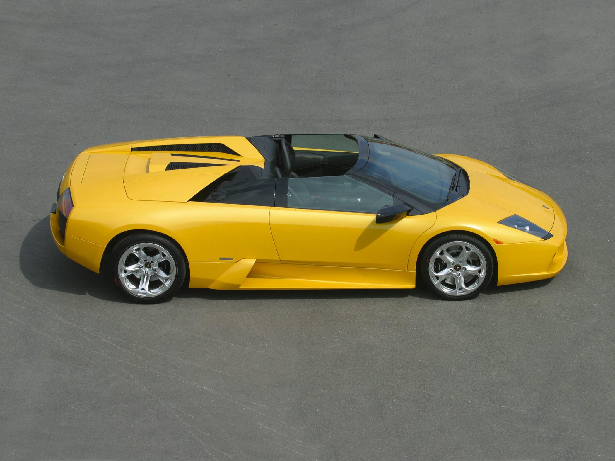Yellow convertible sports car side profile with aerodynamic design and open top