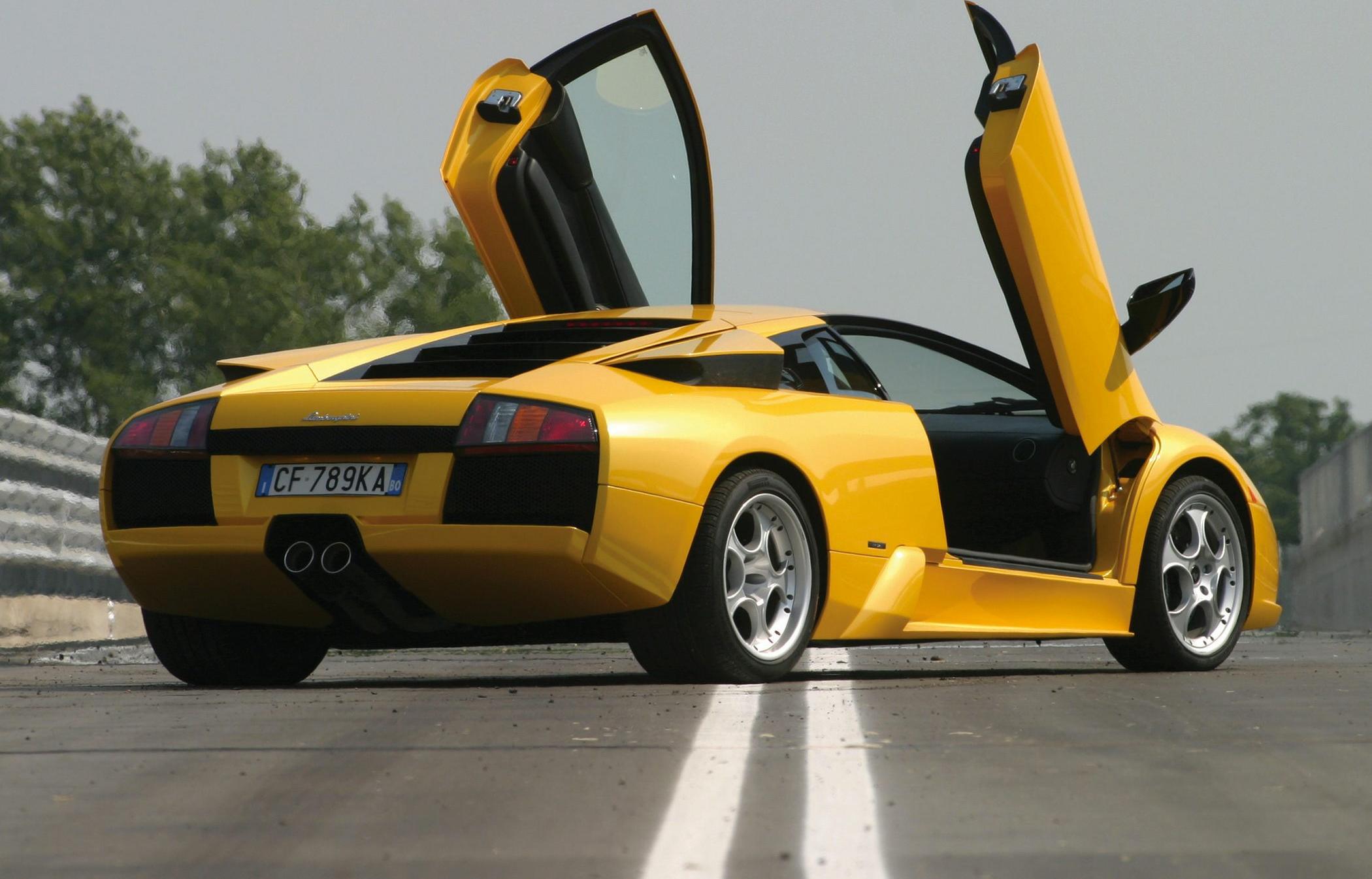 Rear view of yellow sports car with iconic scissor doors open