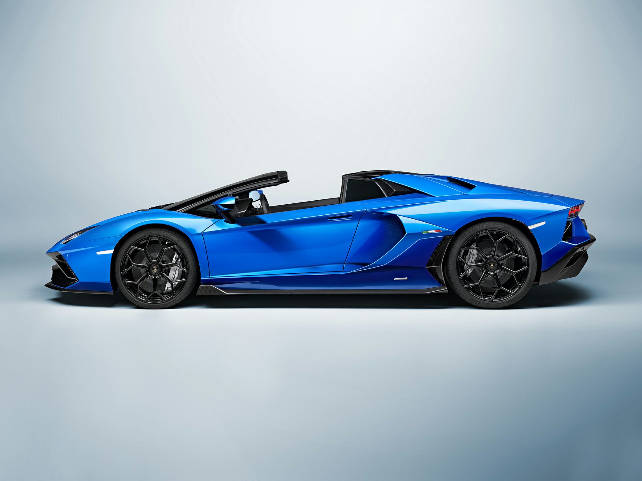Blue convertible with sharp aerodynamic profile and black multi-spoke wheels