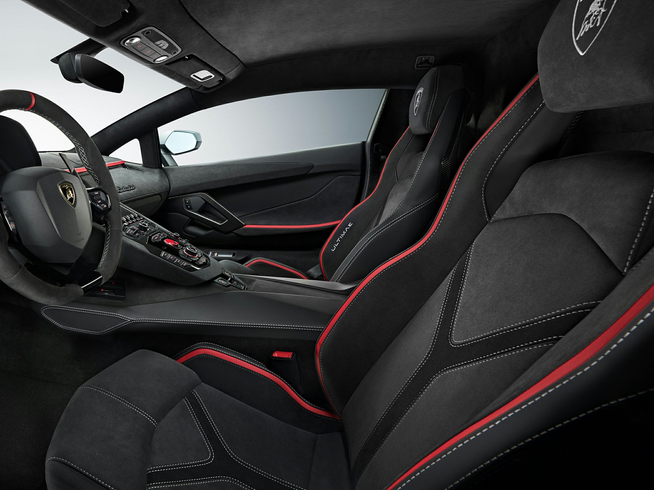 Luxury black and red interior with Alcantara and leather seats, detailed stitching.