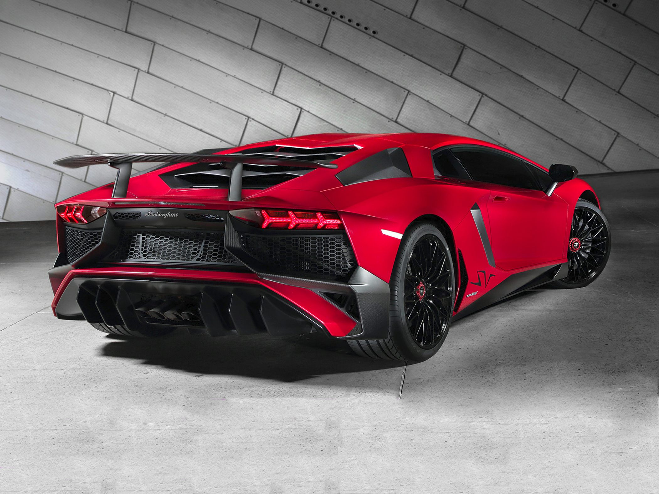 Red supercar rear with large rear wing and diffuser