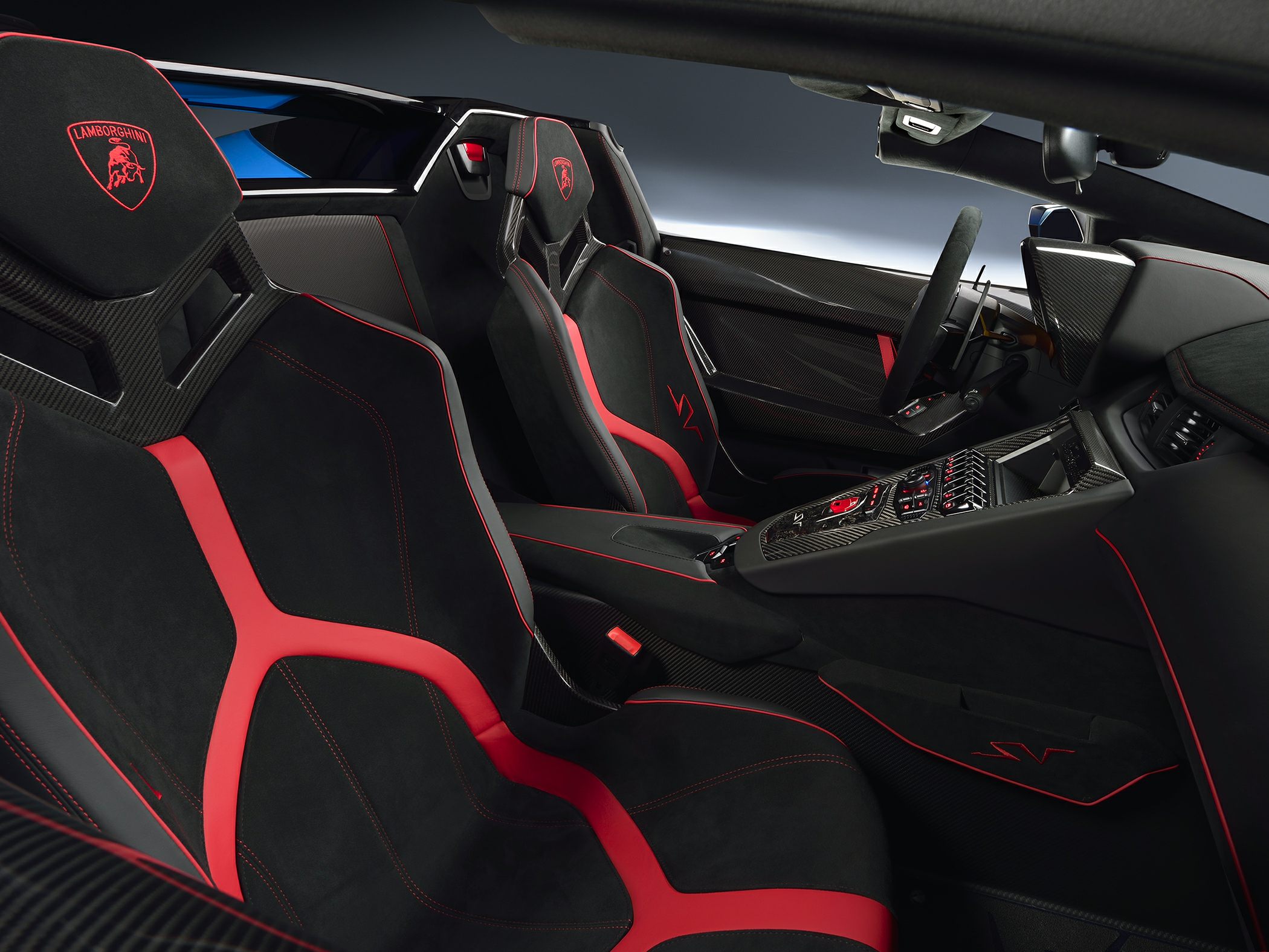 Black and red sports seats with carbon fiber accents inside a luxury performance vehicle