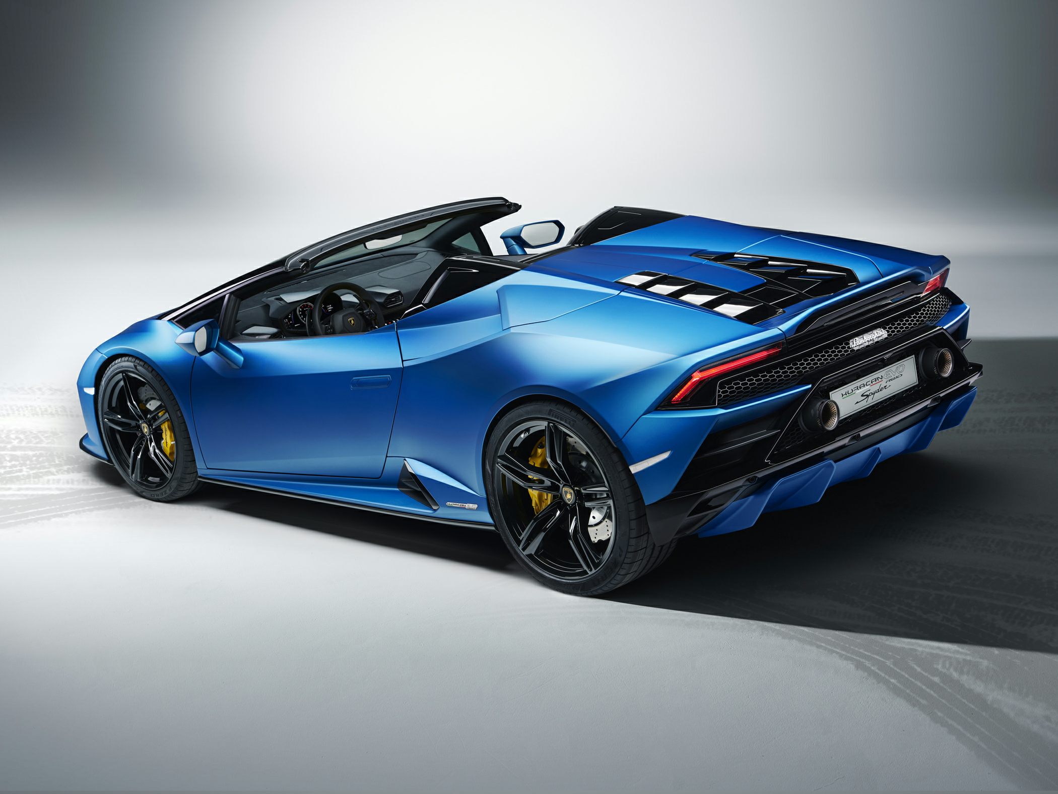 Rear side view of blue convertible with black rims and aerodynamic rear diffuser