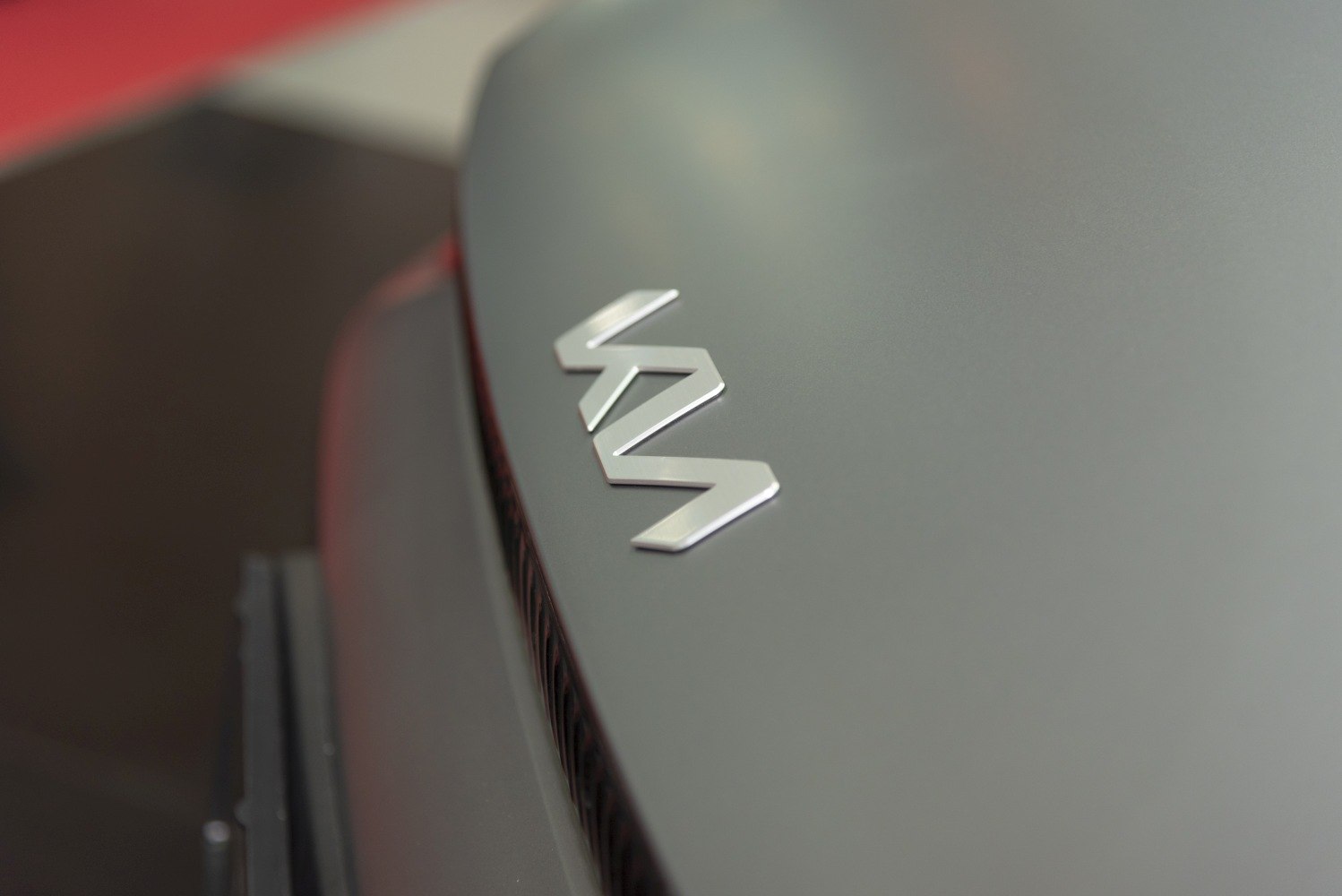 Close-up of modern car emblem on matte surface