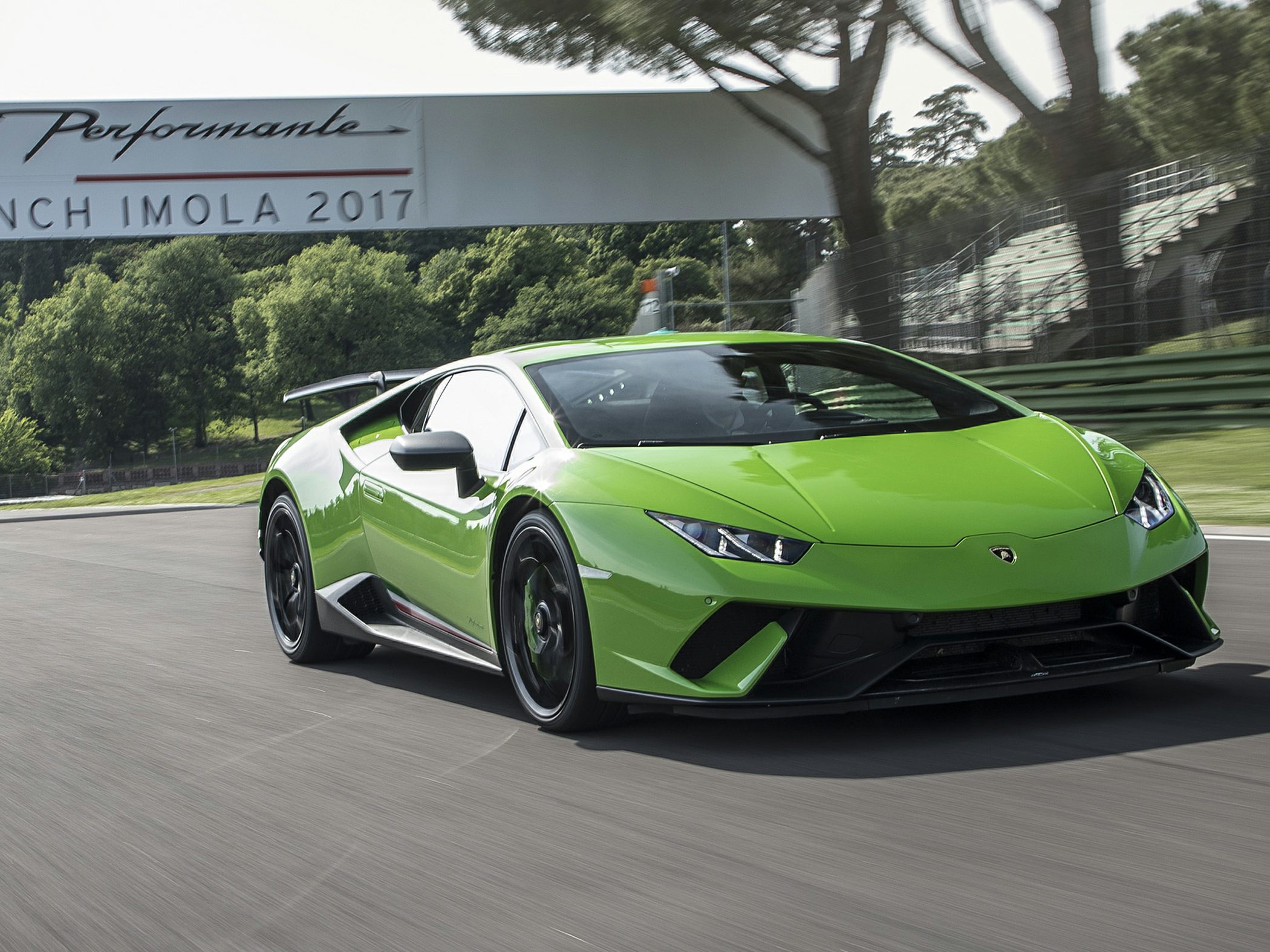 Front-angle view of a sleek sports car in motion on a racetrack