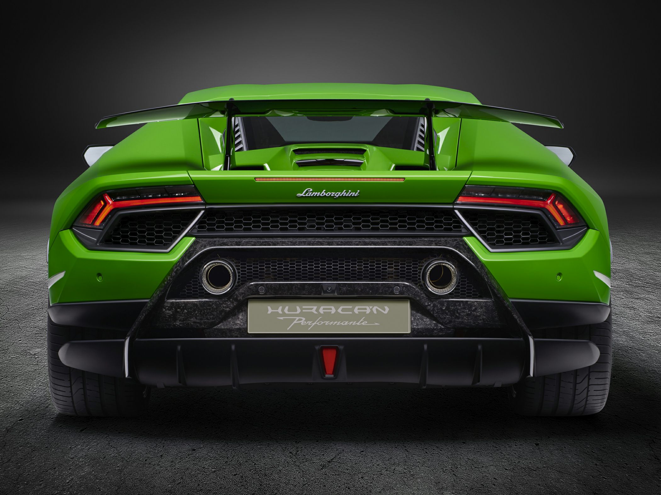 Rear view with wide spoiler, aggressive taillights, and dual exhausts