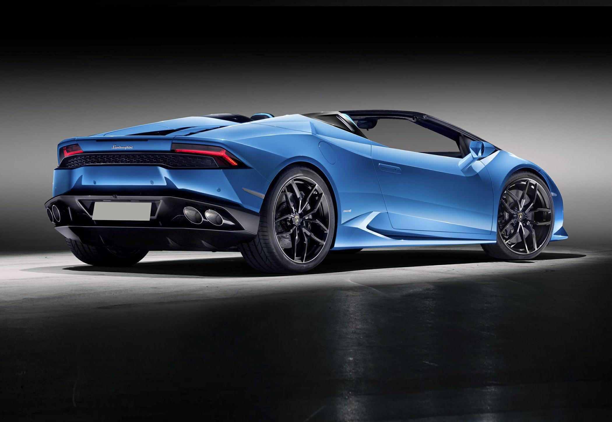 Rear-side view including rear lights, quad exhausts, and convertible roof.