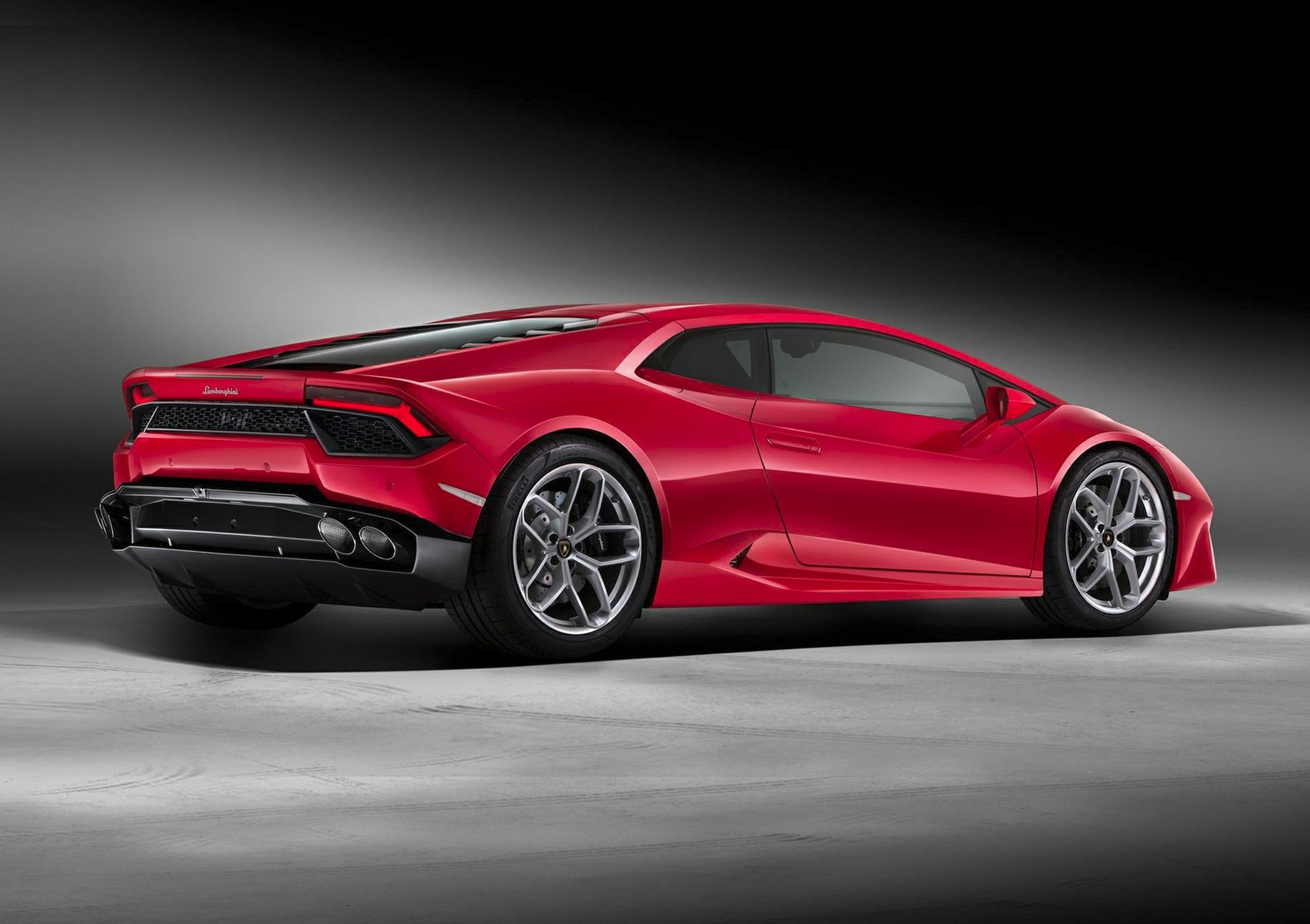 Side rear view of a red sports car with aggressive rear design and alloy wheels
