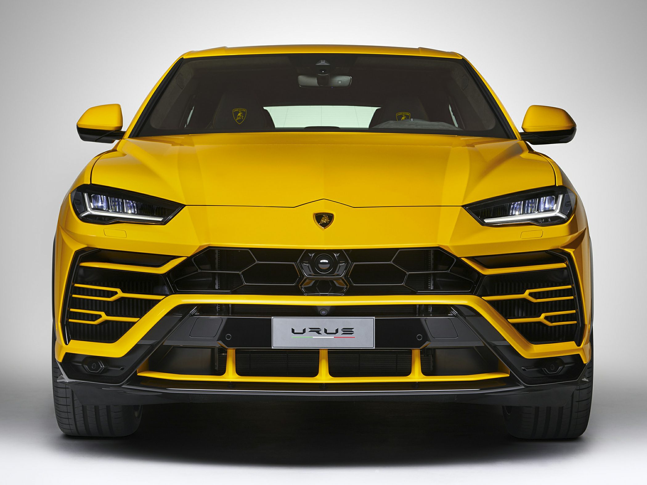 Yellow SUV front view with hexagonal grille and LED headlights