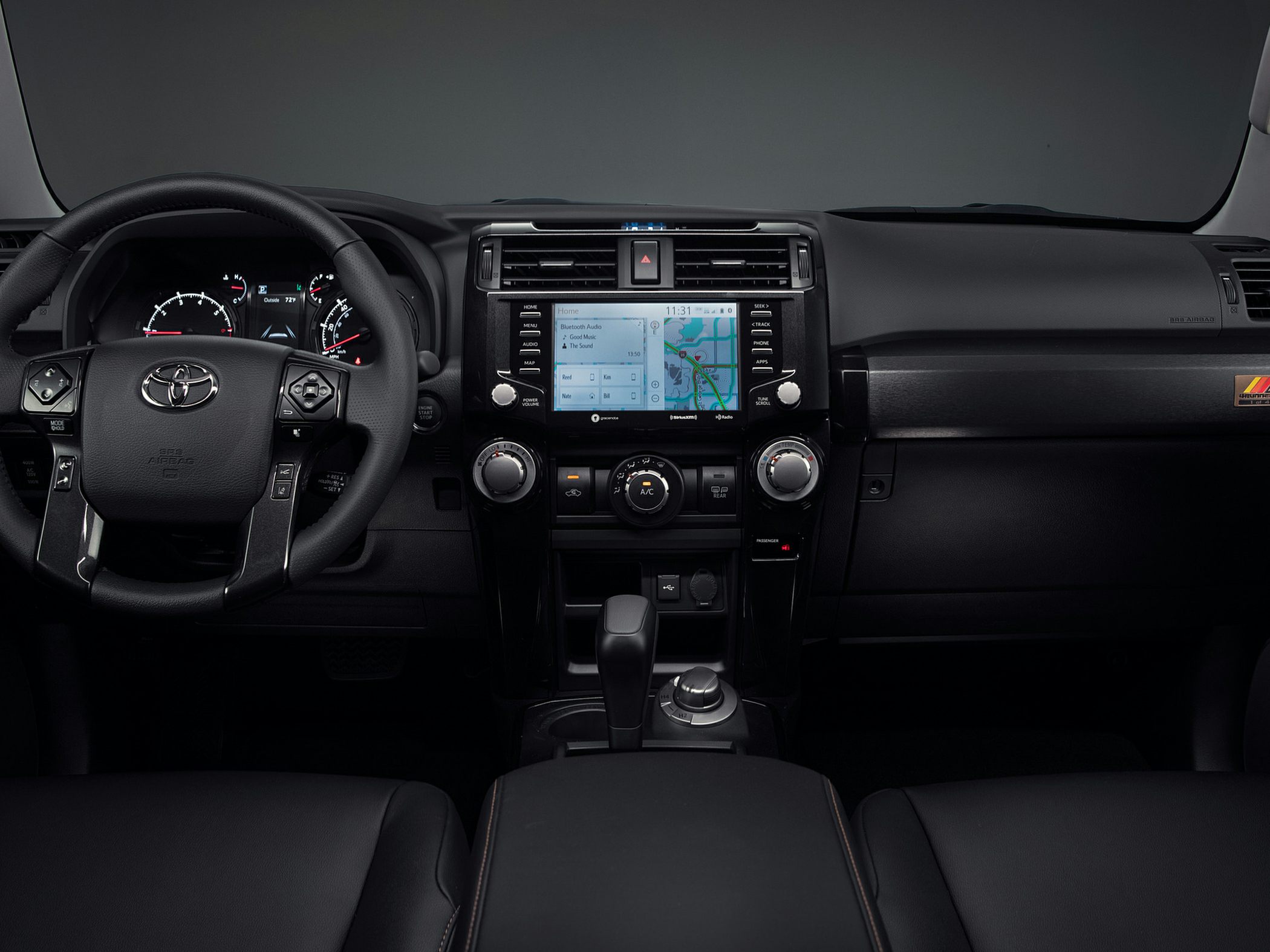 Dashboard with infotainment screen and climate controls, steering wheel with buttons